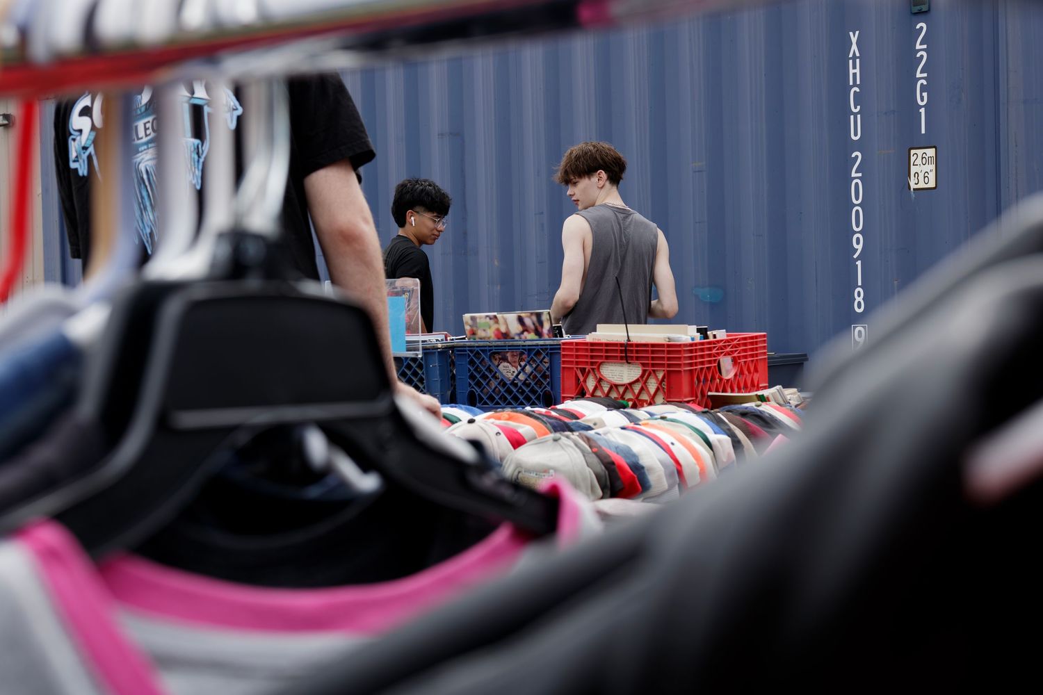 Shoppers exploring a fashion market with colorful clothing displays, photographed by local fashion photographer.