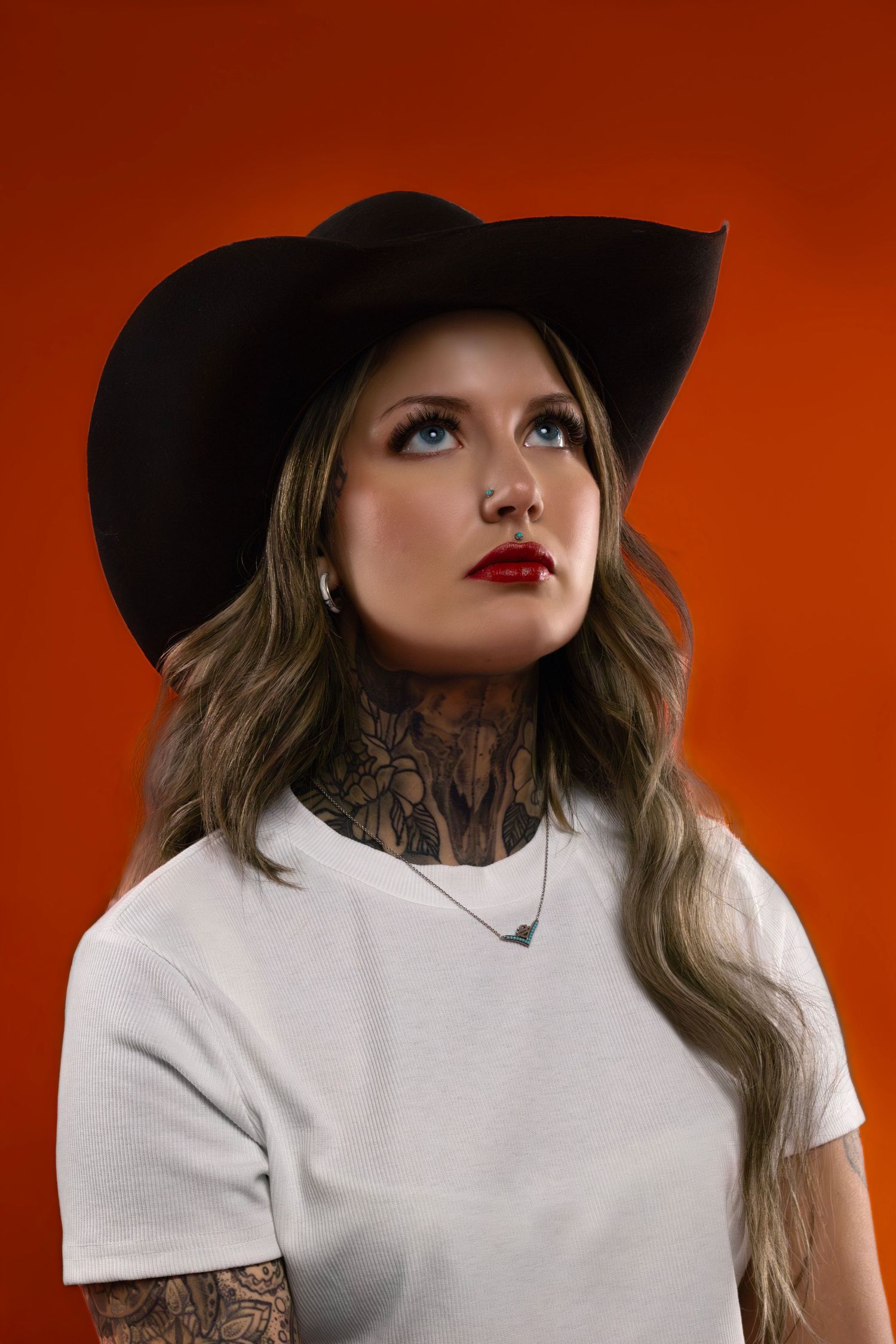 Studio editorial portrait with orange backdrop, modern western Americana theme, captured by Sioux Falls fashion photographer.