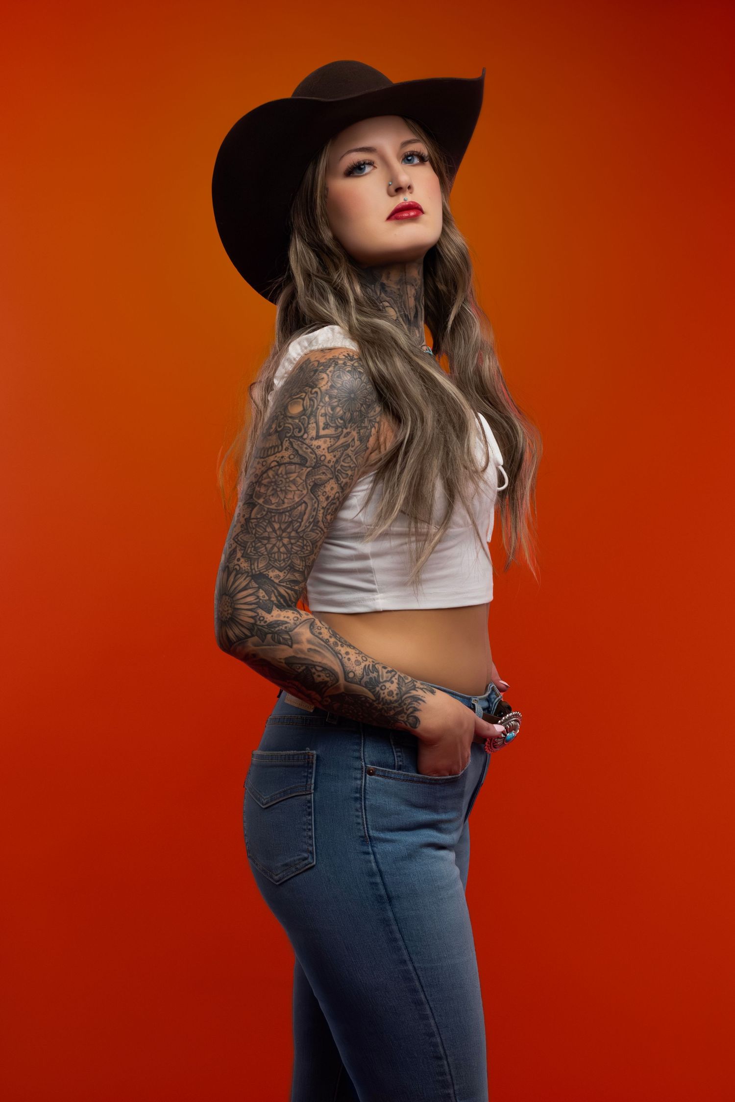 Orange backdrop editorial studio portrait, showcasing modern western style, creative fashion, and professional photography in Sioux Falls.