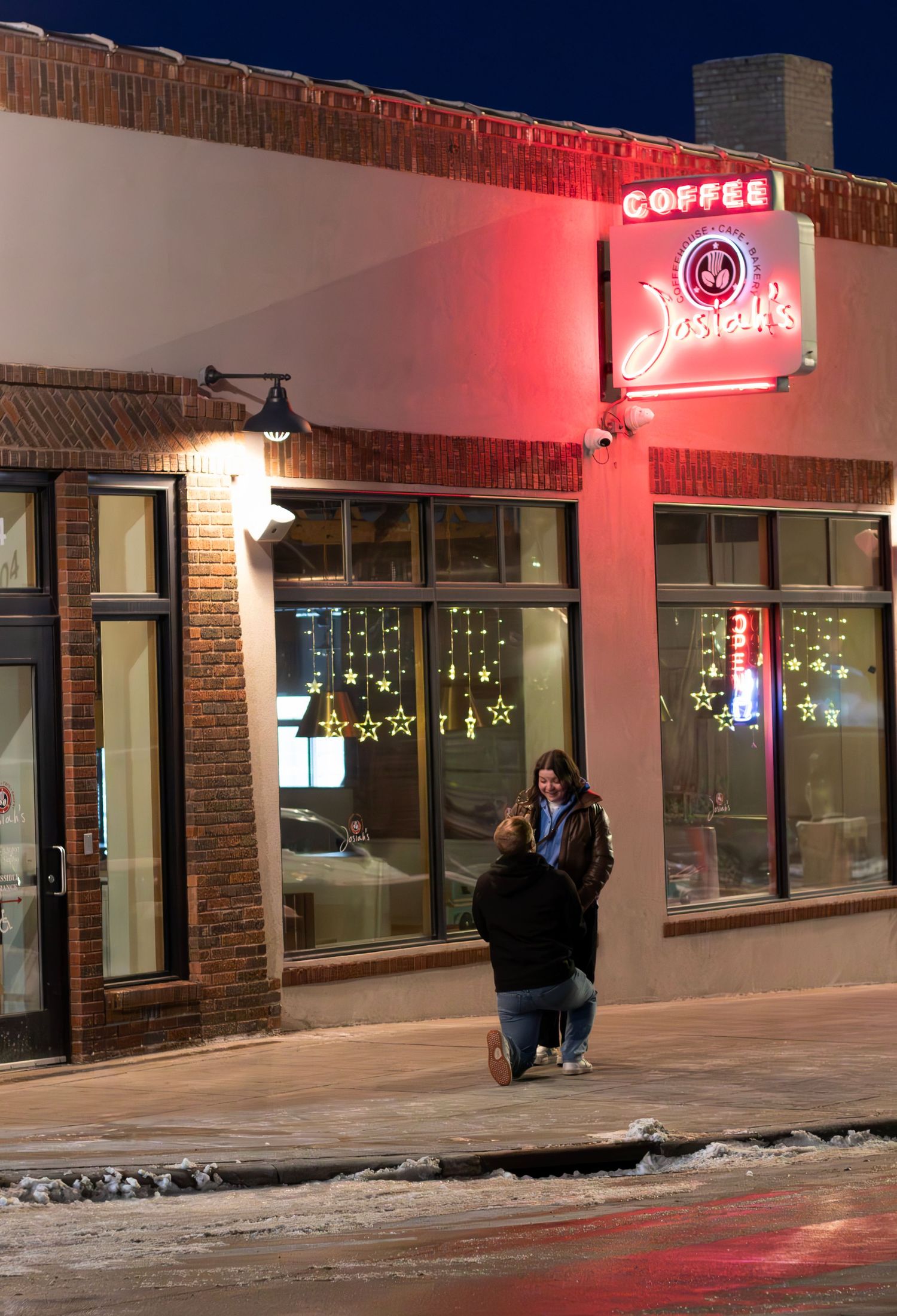 Surprise engagement outdoors, couple celebrating love, joyful candid portraits, engagement photography in downtown Sioux Falls