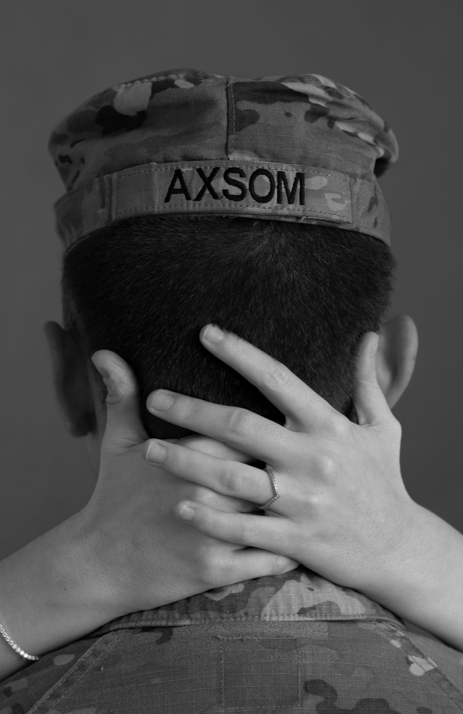 Back view of military cap with hands touching neck during a fine art couples photoshoot in a professional studio in Sioux Falls, SD.
