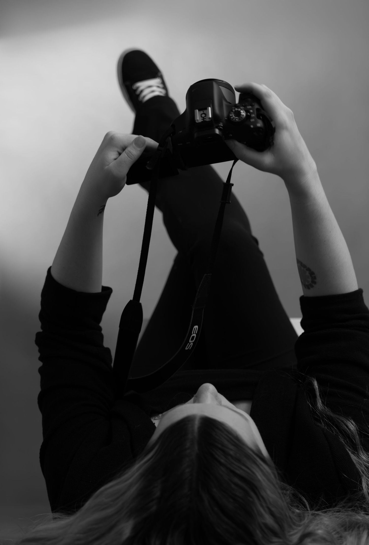 Overhead branding shot of Bree from Sixtwentytwo Images holding a Canon camera. Minimalist black and white brand photography for creatives.