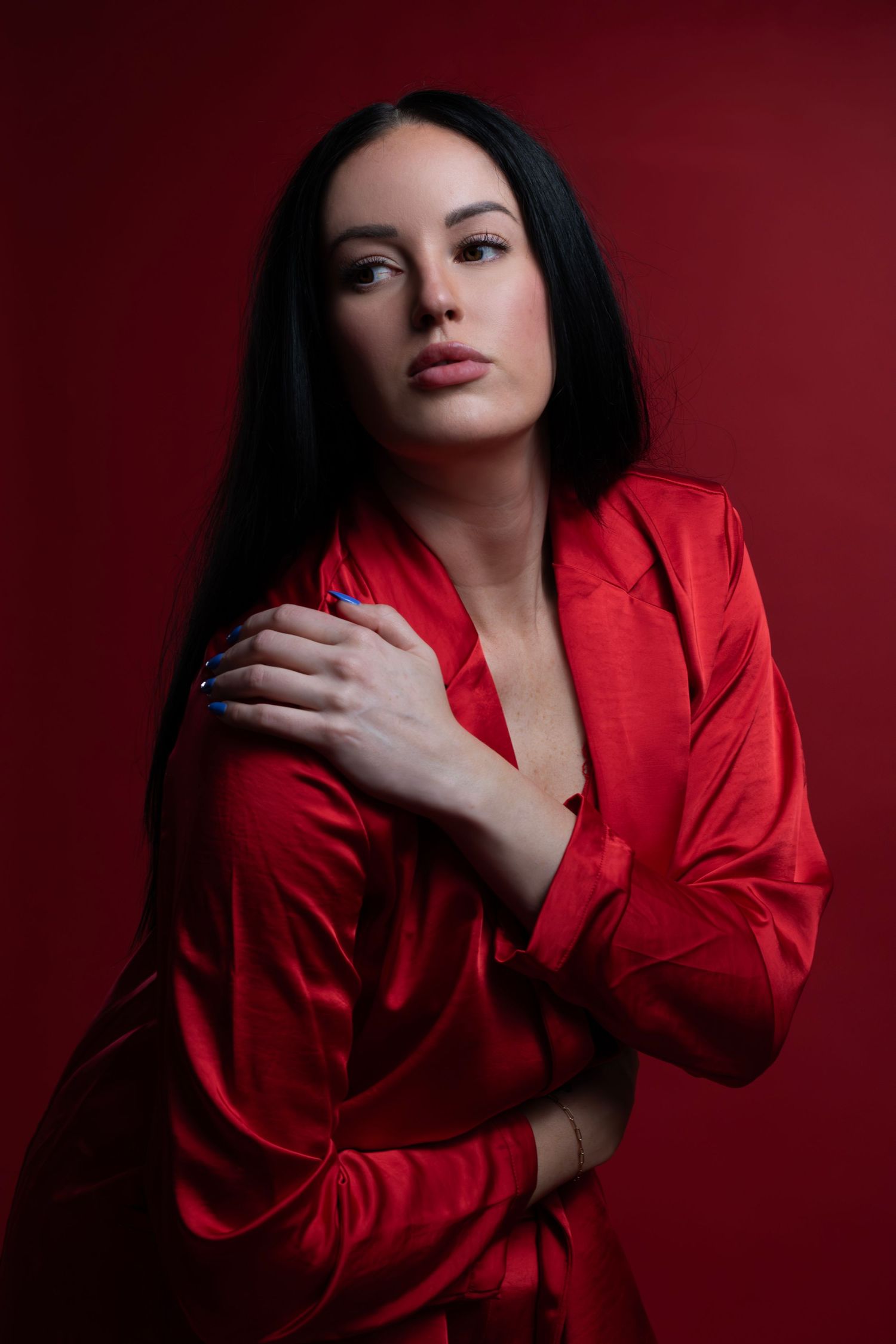 Studio portrait of a woman in red outfit, captured by Sioux Falls fashion photographer emphasizing bold style and editorial looks.
