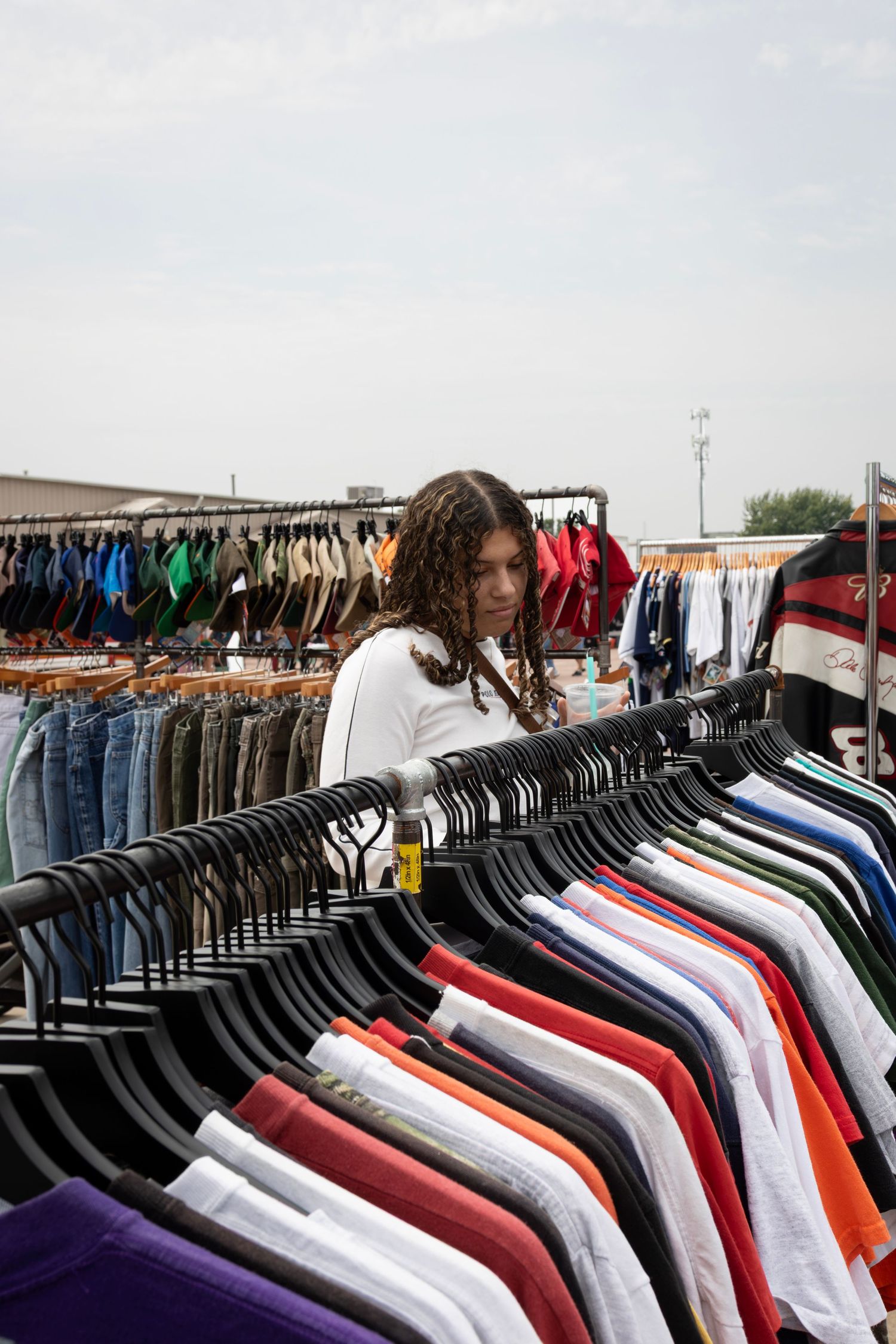 Shoppers exploring outdoor market stalls with unique apparel, photographed by local Sioux Falls fashion photographer.