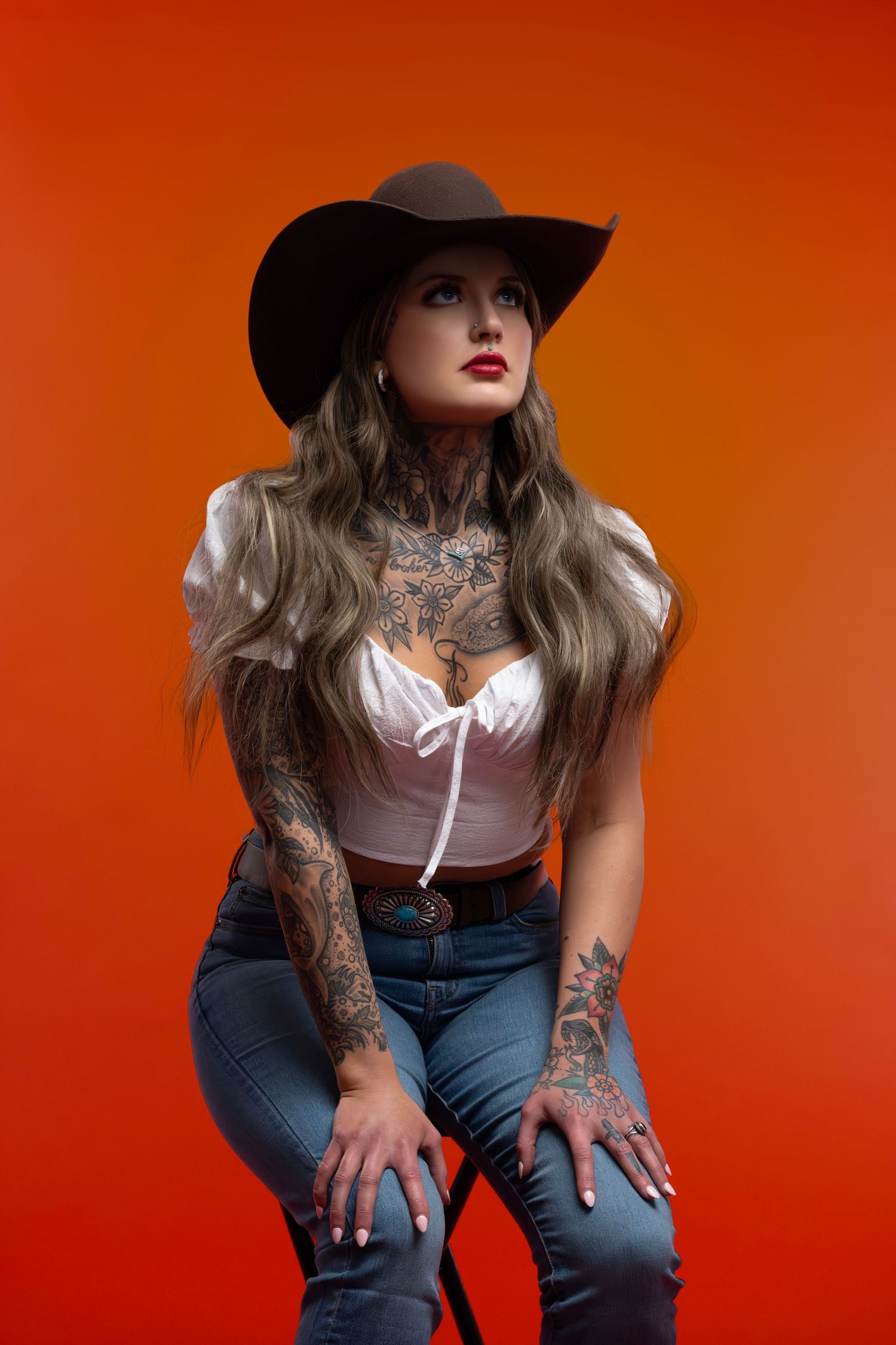 Modern Americana studio portrait with orange backdrop, Sioux Falls photographer emphasizing editorial style, fashion, and unique composition