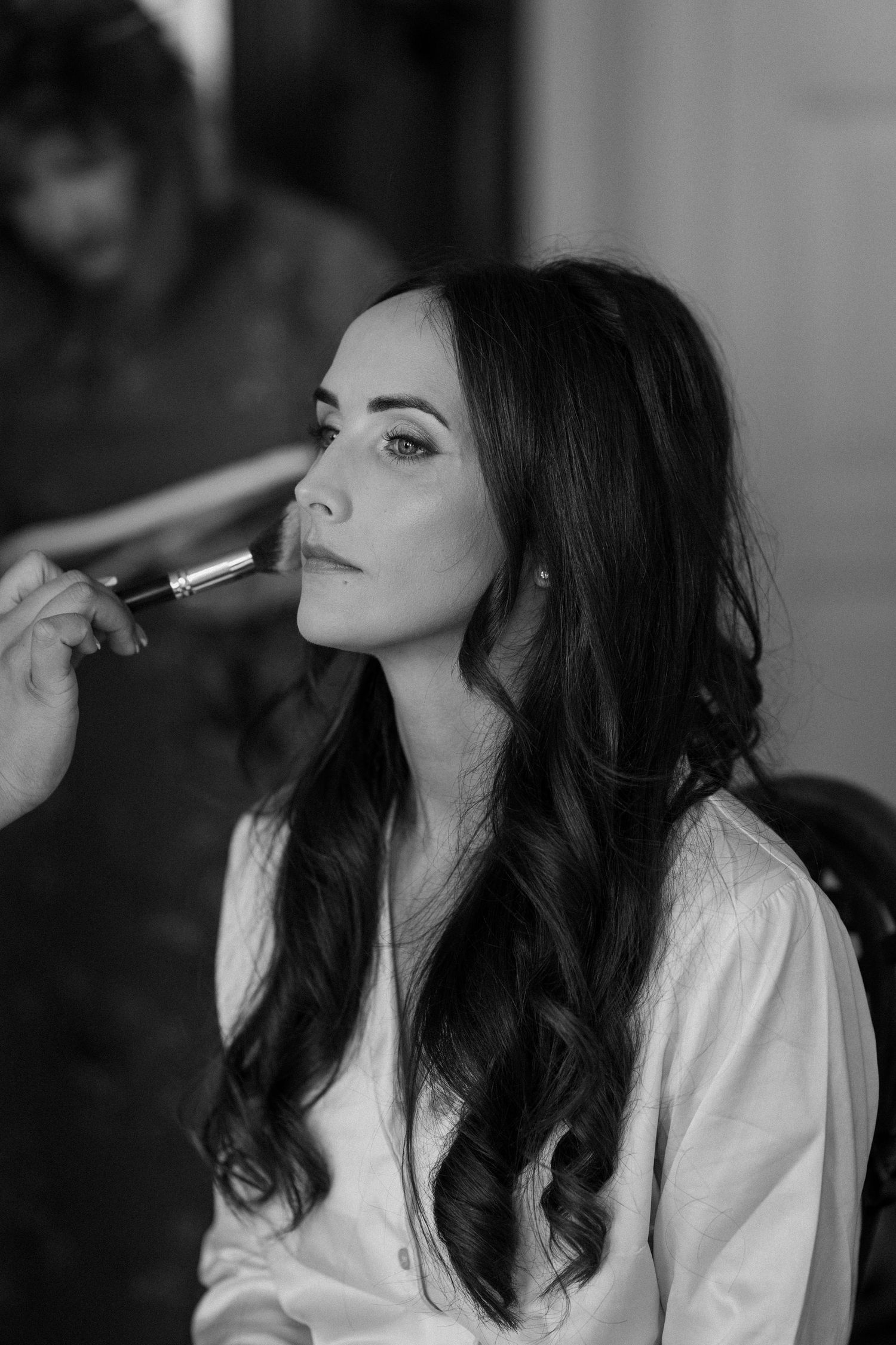 A black and white photo showing wedding day makeup application preparations at Ettington Park Hotel.