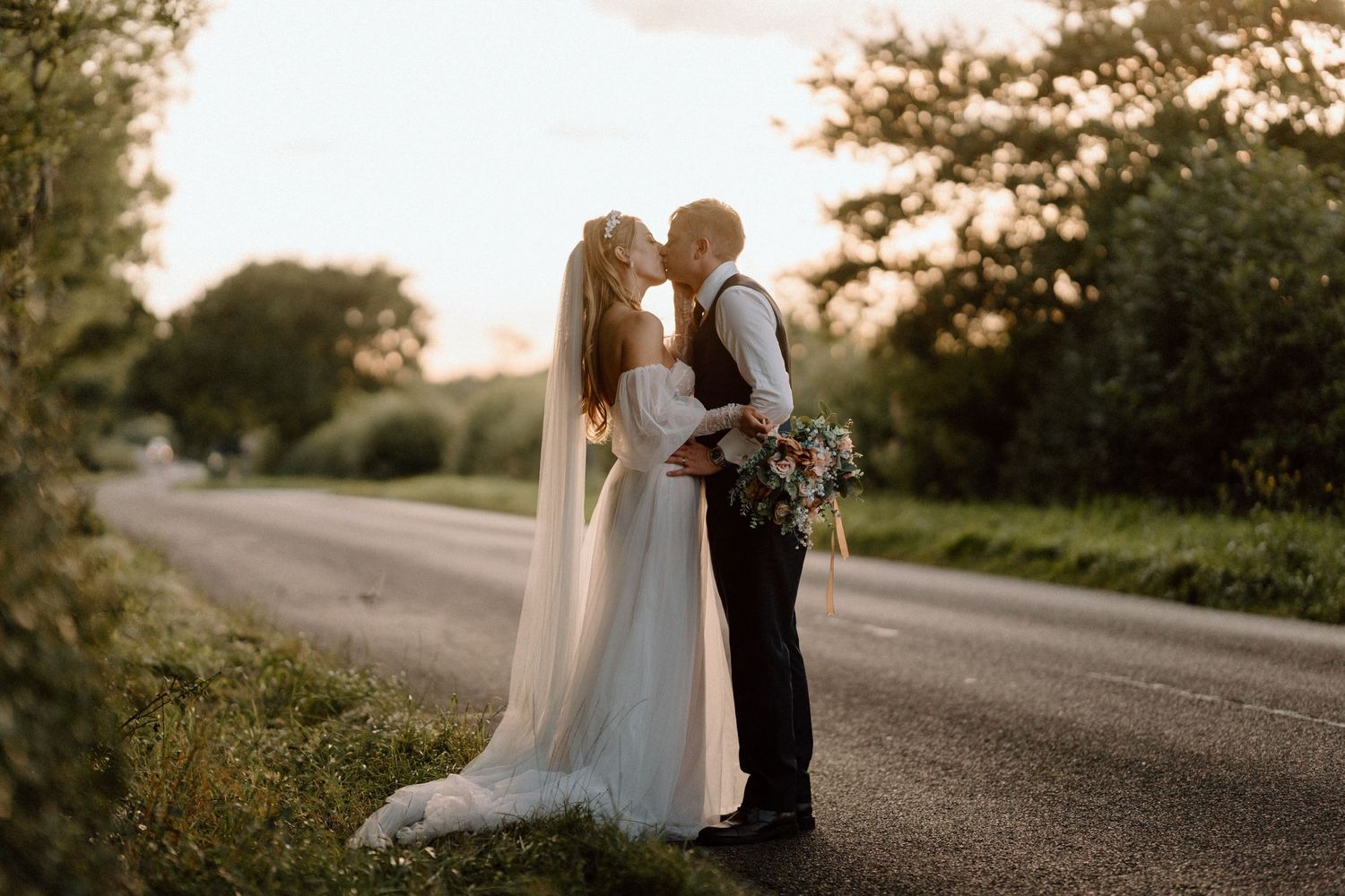 A romantic sunset wedding portrait on a quiet country road.