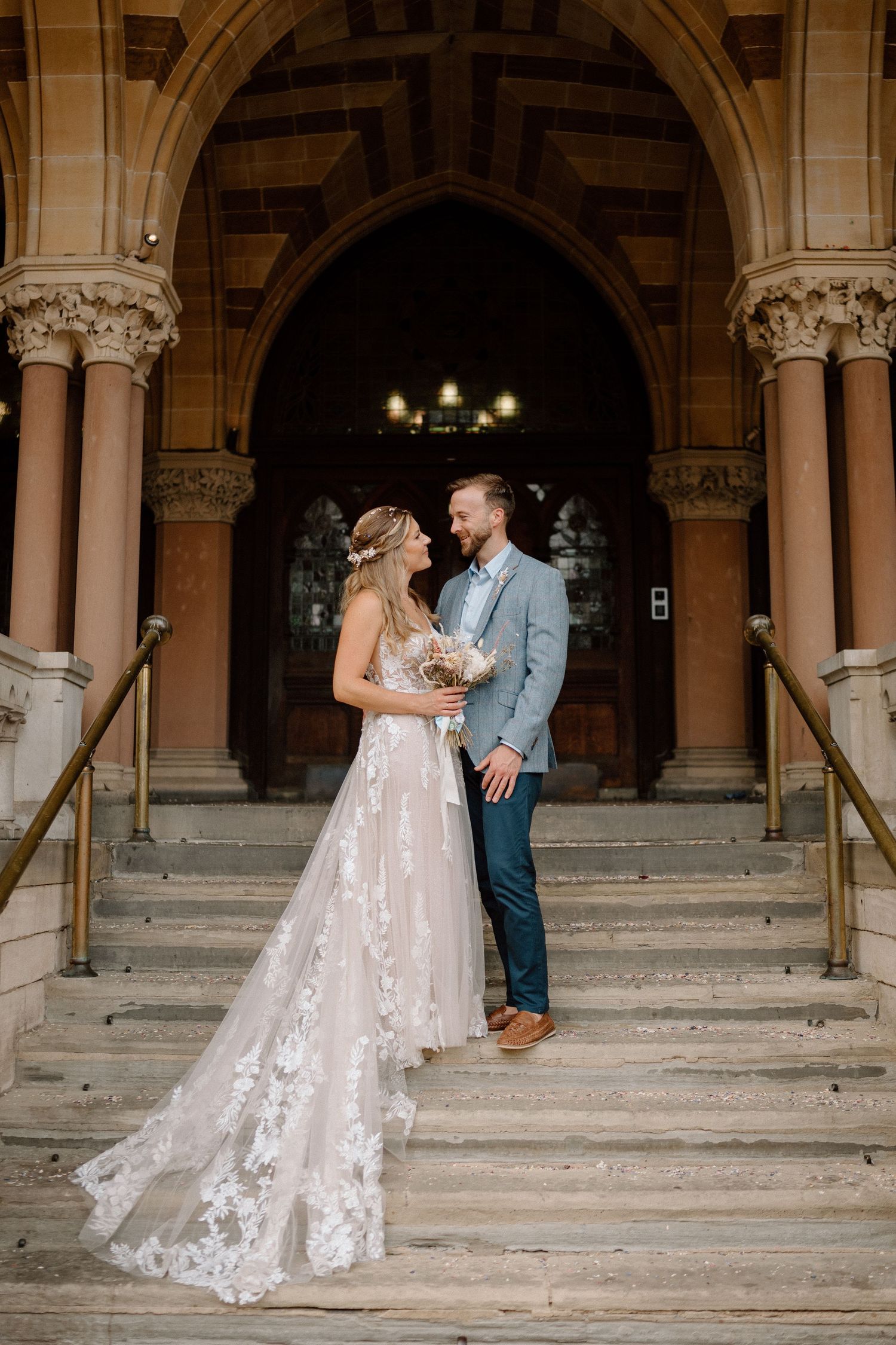 Couple shares romantic moment on grand stone steps of historic church during their wedding in Northampton.