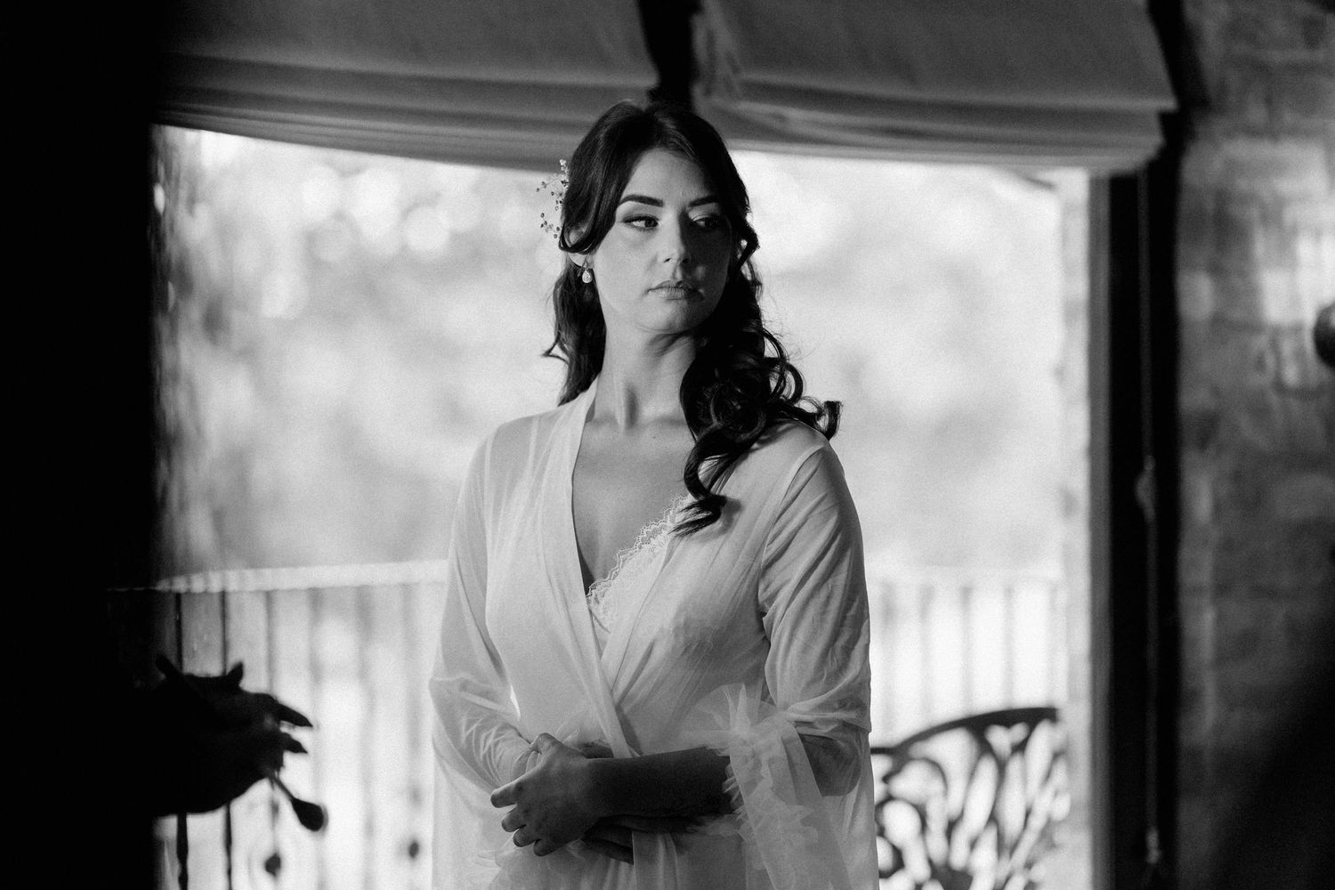Black and white photo series of someone getting ready on their wedding day in a sunlit room.