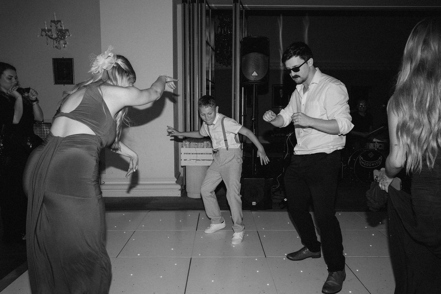 Wedding guests dancing and celebrating on a monochrome dance floor.