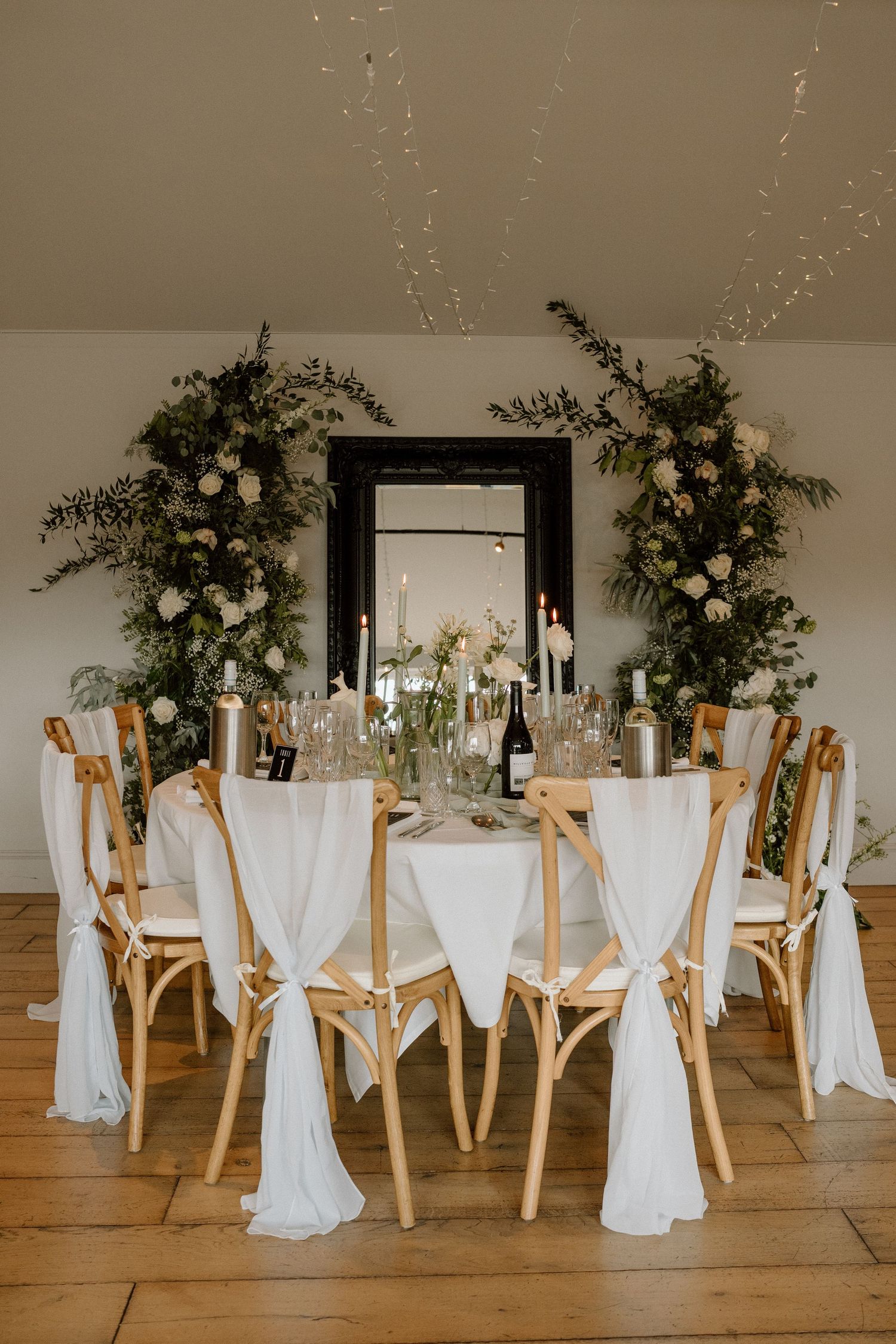 Elegant wedding table setting with white linens, wooden chairs, and floral arrangements  at The Manor House at Quorn.