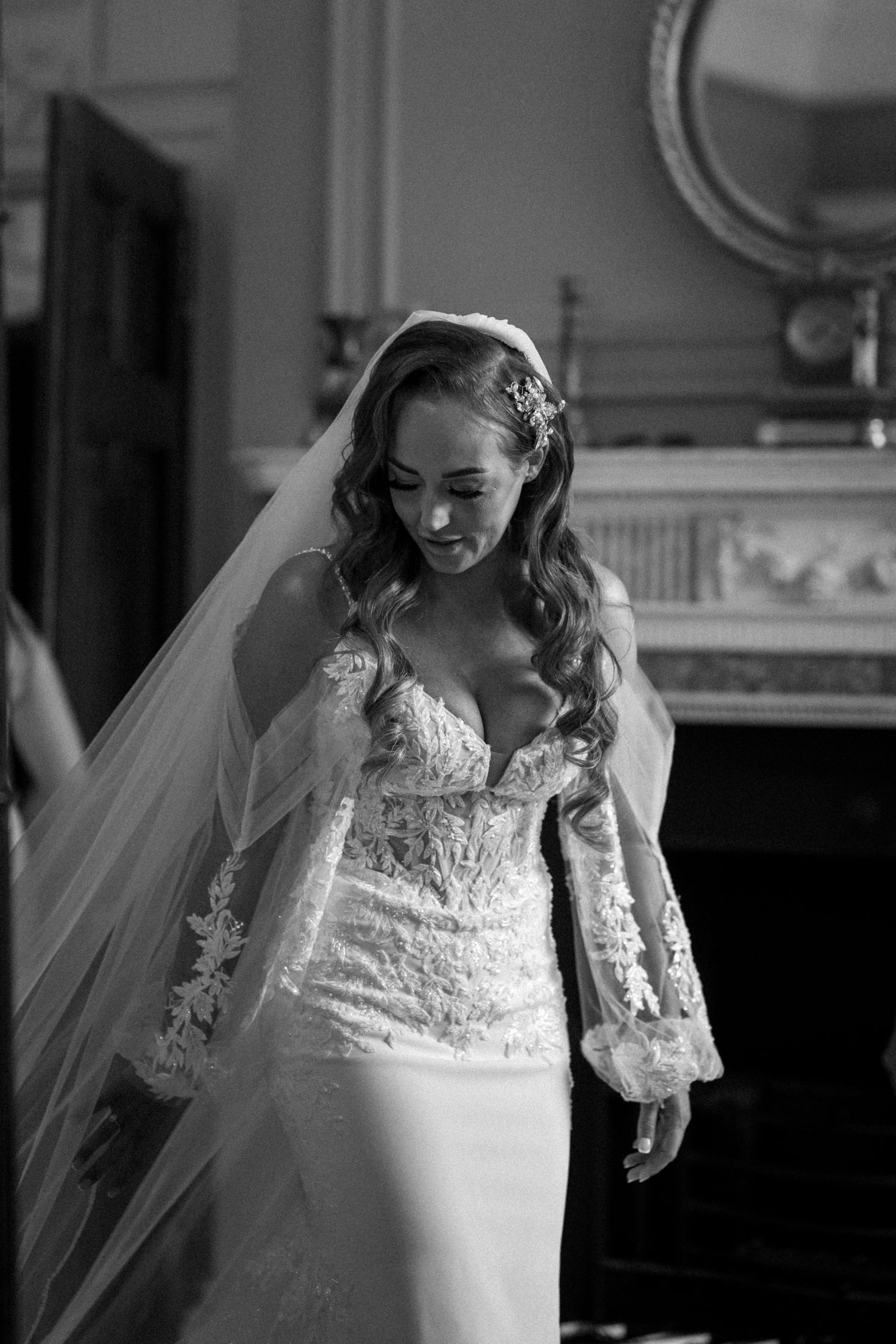 A sequence of black and white portraits showing details of a bride's elegant lace wedding dress and flowing veil.