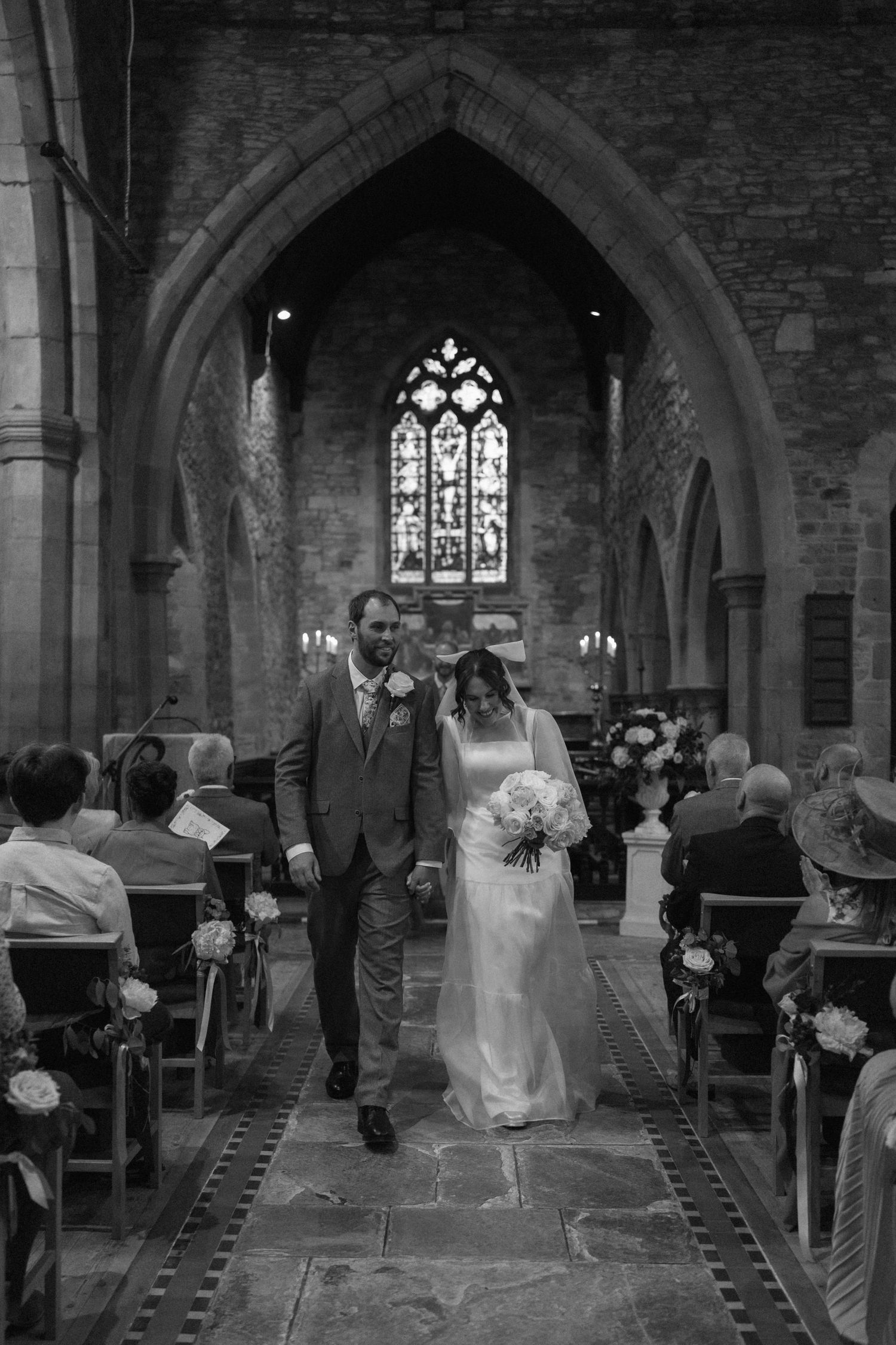 A wedding ceremony in a historic stone church with stained glass windows and wooden pews in Barby.