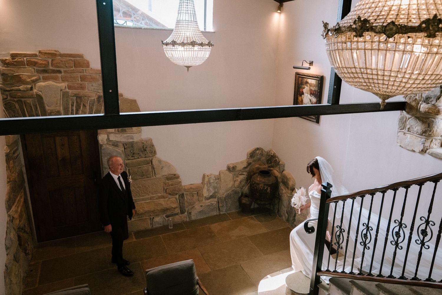 Elegant rustic wedding venue interior with stone walls and hanging chandeliers creates a romantic ambiance.