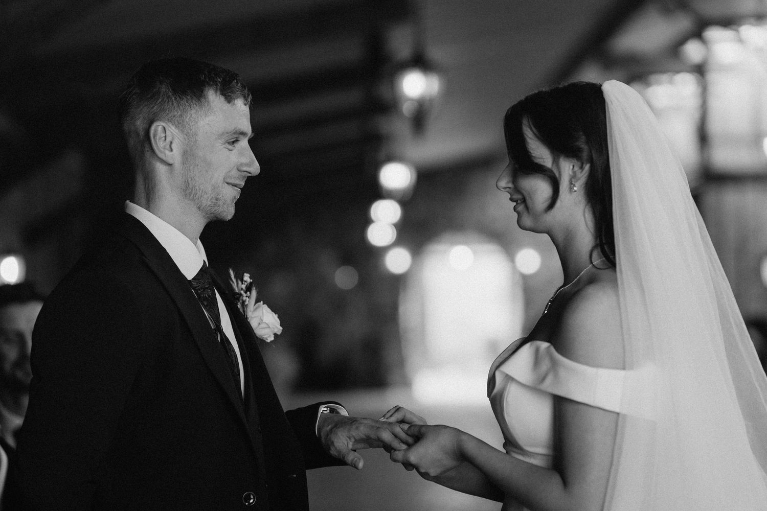 Touching black and white image of a wedding ceremony with soft lighting and a romantic atmosphere.