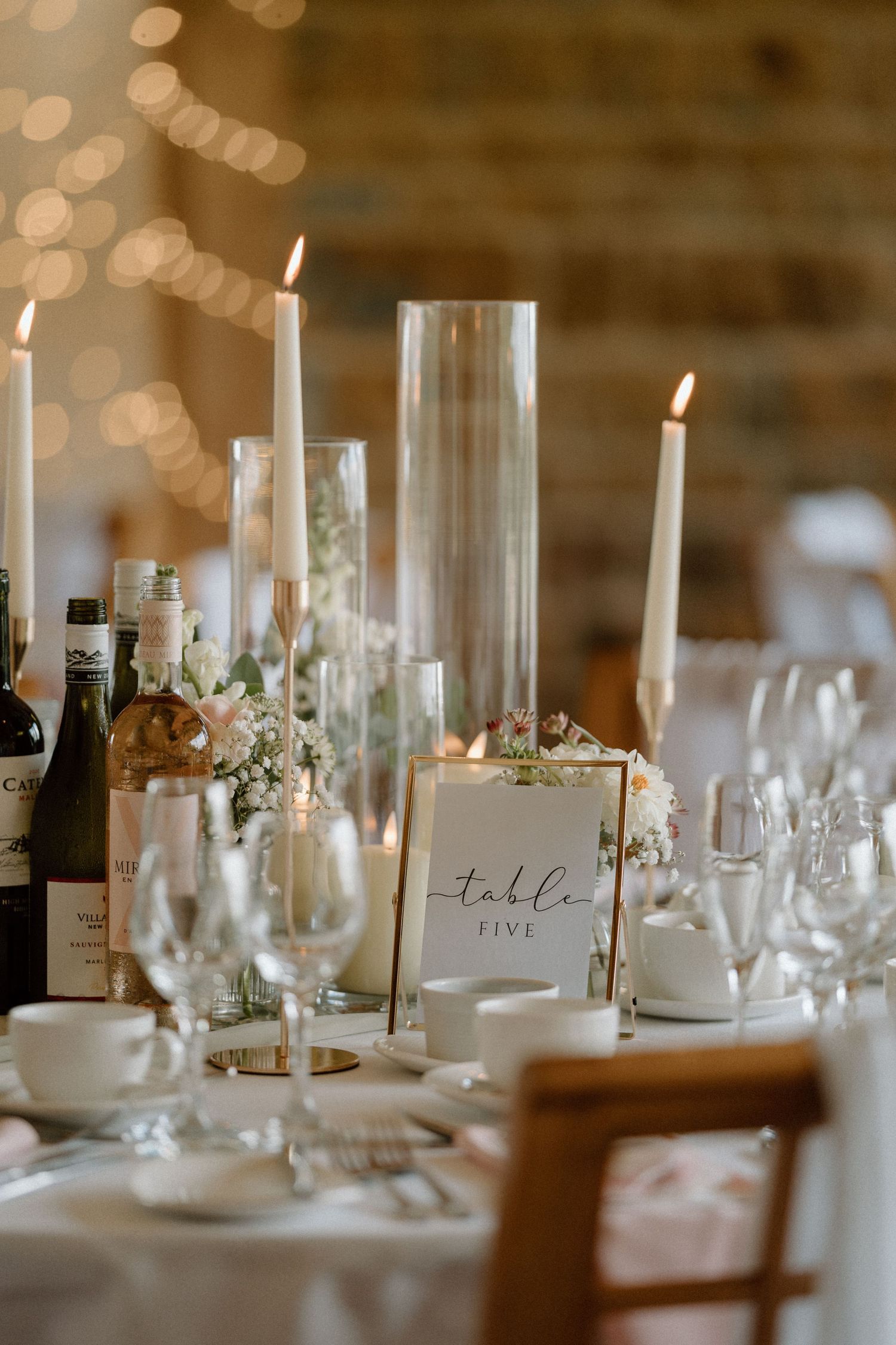 Elegant wedding reception table setting with candles, wine glasses and table number at Dodford Manor.