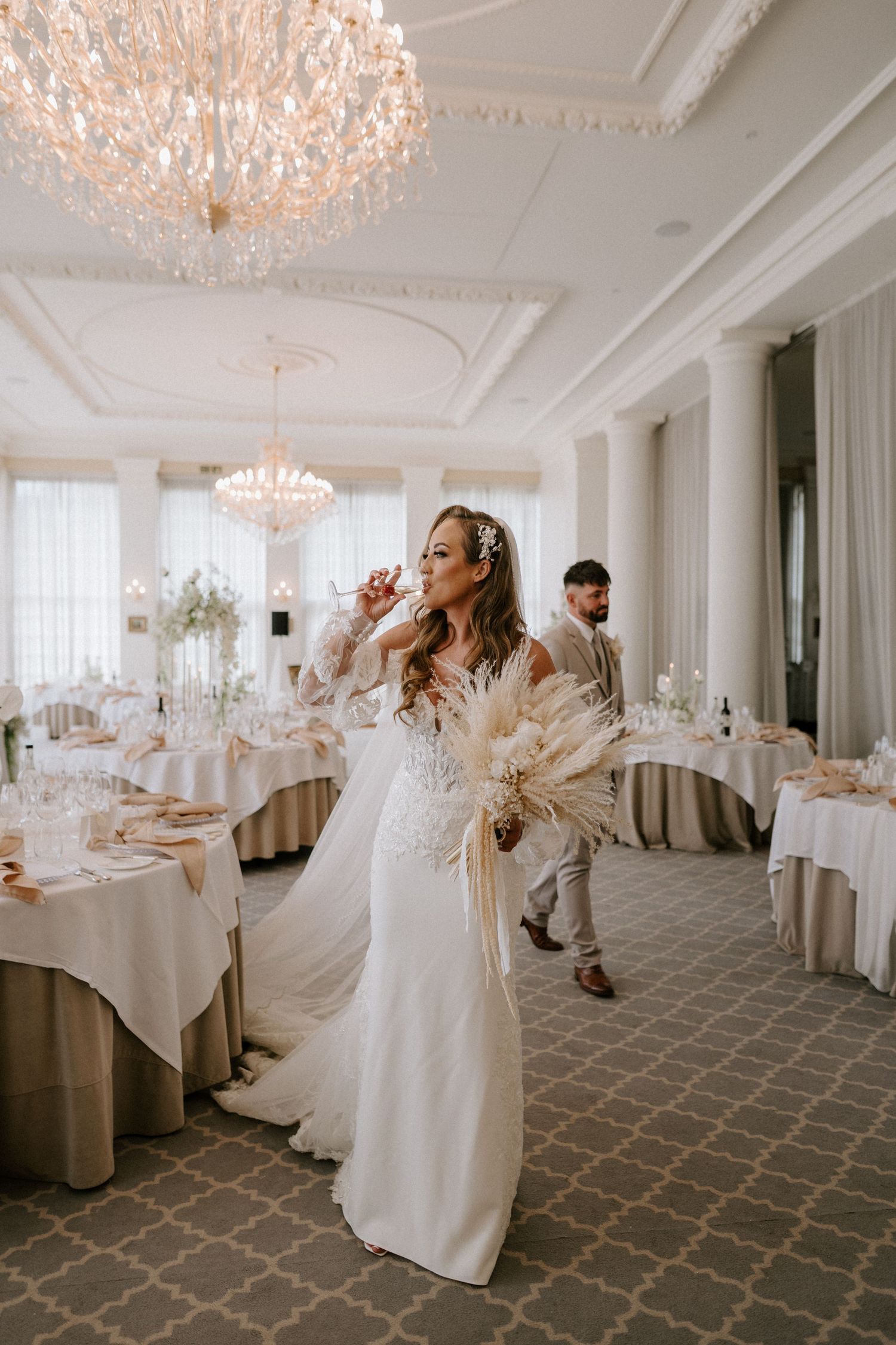 Dancing figure in flowing white gown twirls gracefully across an elegant ballroom with crystal chandeliers.
