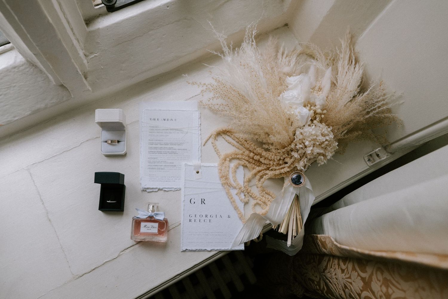 Neutral-toned feathered fascinator displayed on a white surface with scattered papers in the background.