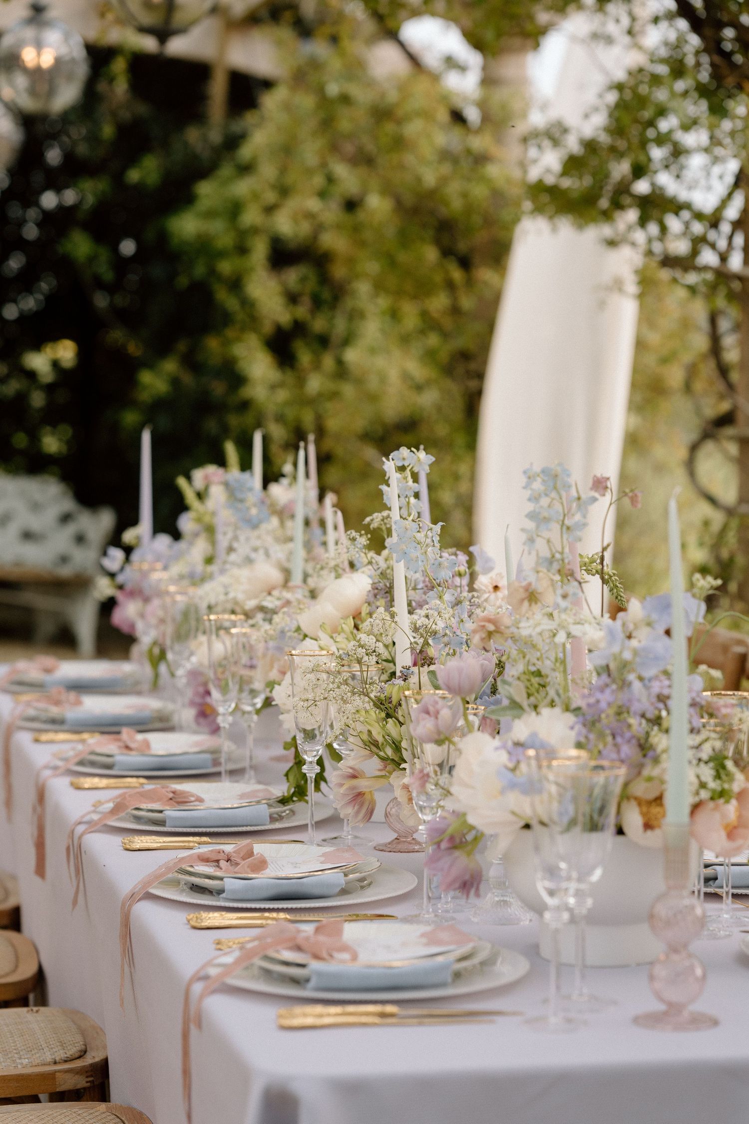 An elegant wedding table setting with delicate pink flowers and fine china.