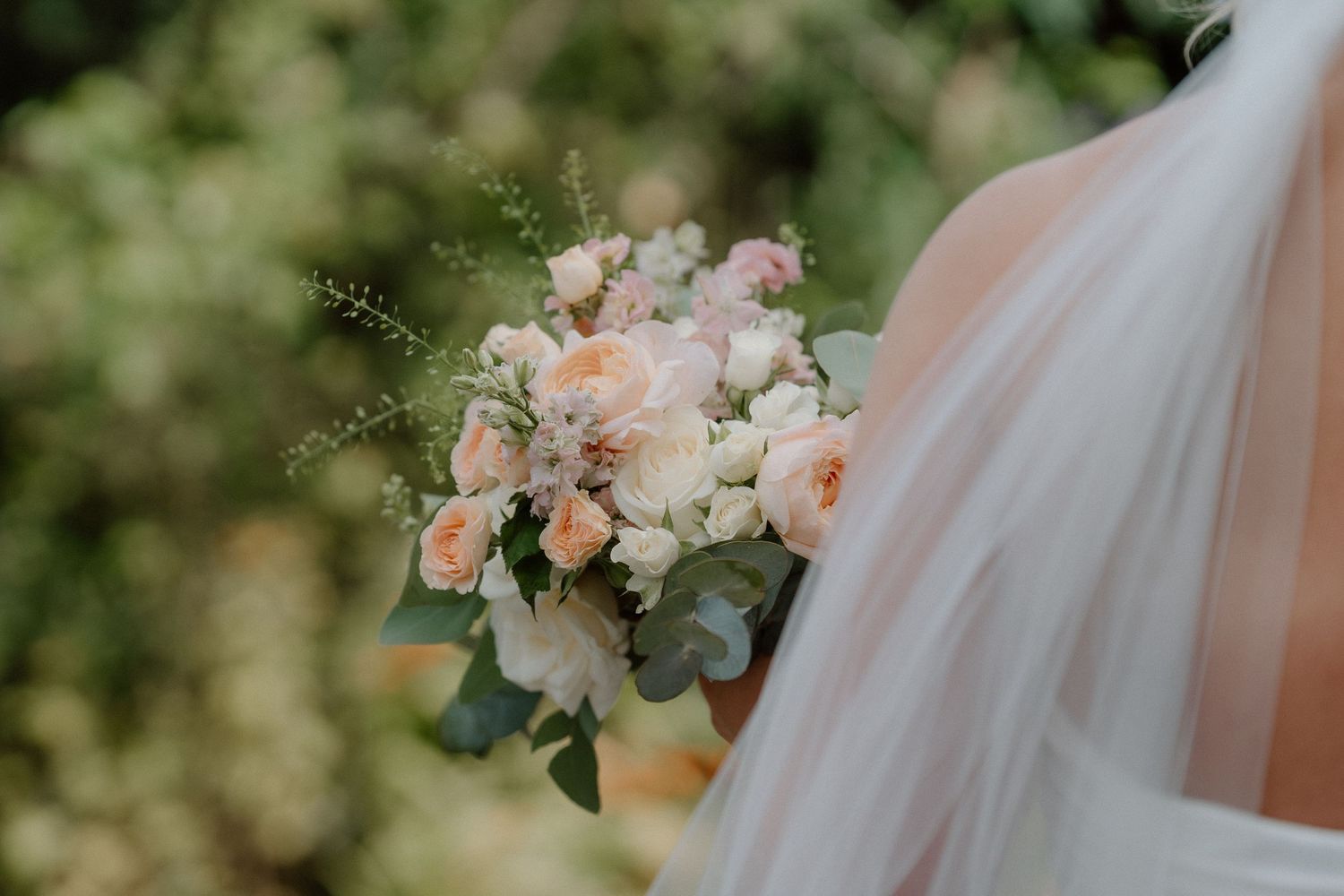A delicate bridal bouquet featuring soft pink roses and white flowers with eucalyptus greenery at Nuthurst Grange.