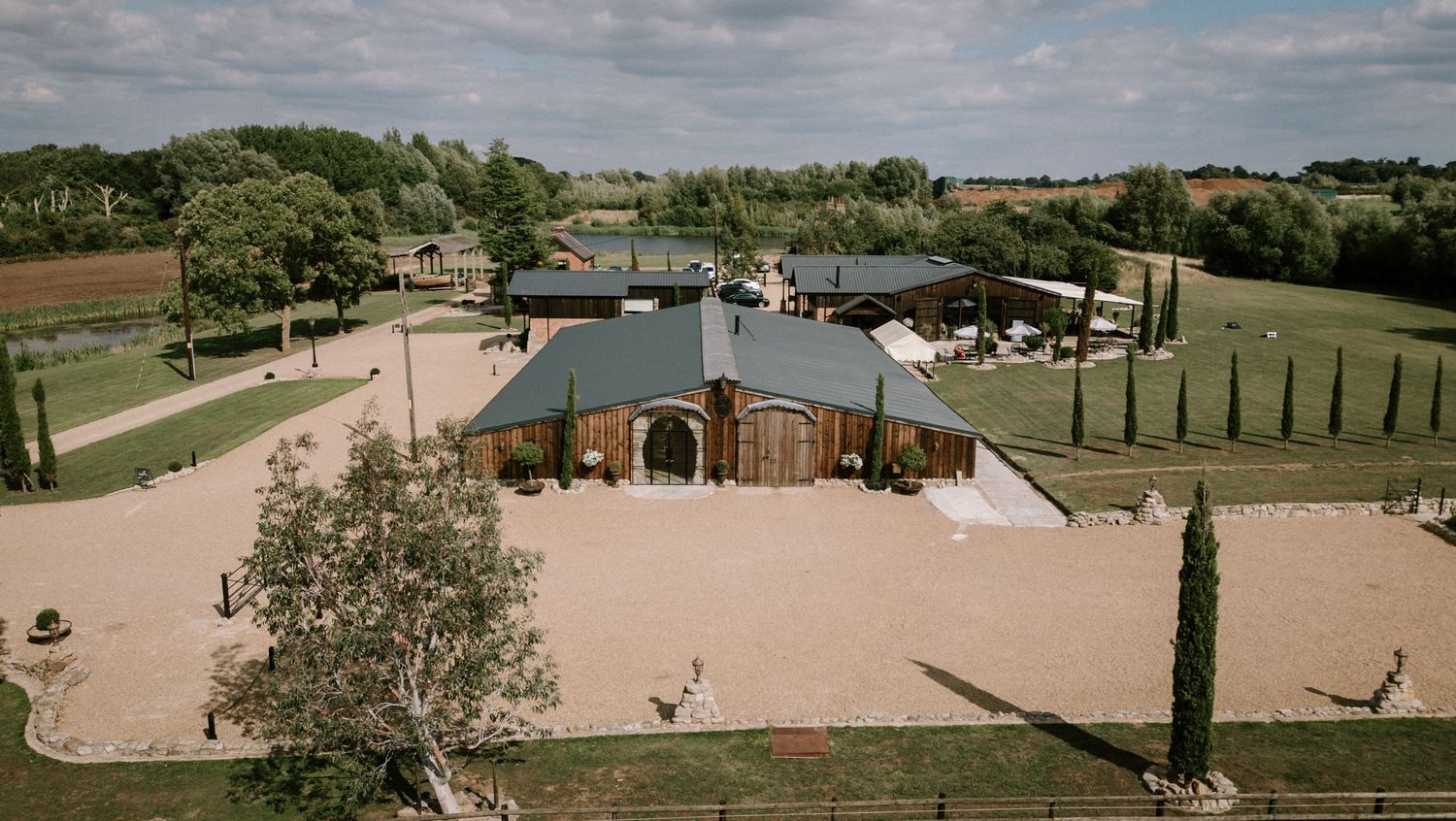 Aerial view of a beautiful brick venue with manicured grounds and cypress trees.