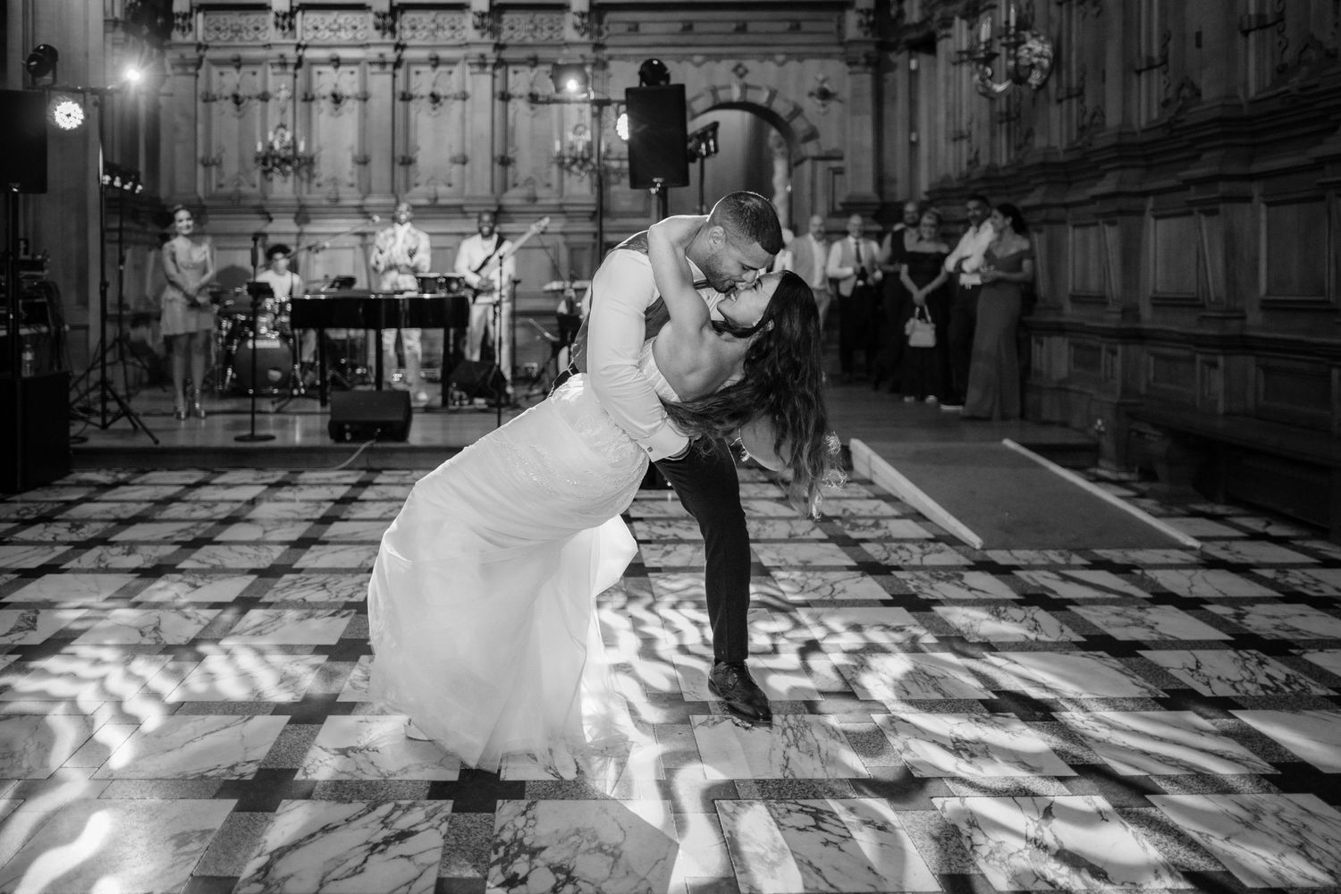 A dramatic black and white photo of a wedding couple dancing in a patterned light ballroom at Harlaxton Manor.