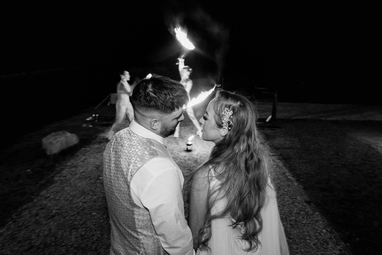 A dramatic nighttime portrait with sparklers creating light trails in the darkness.
