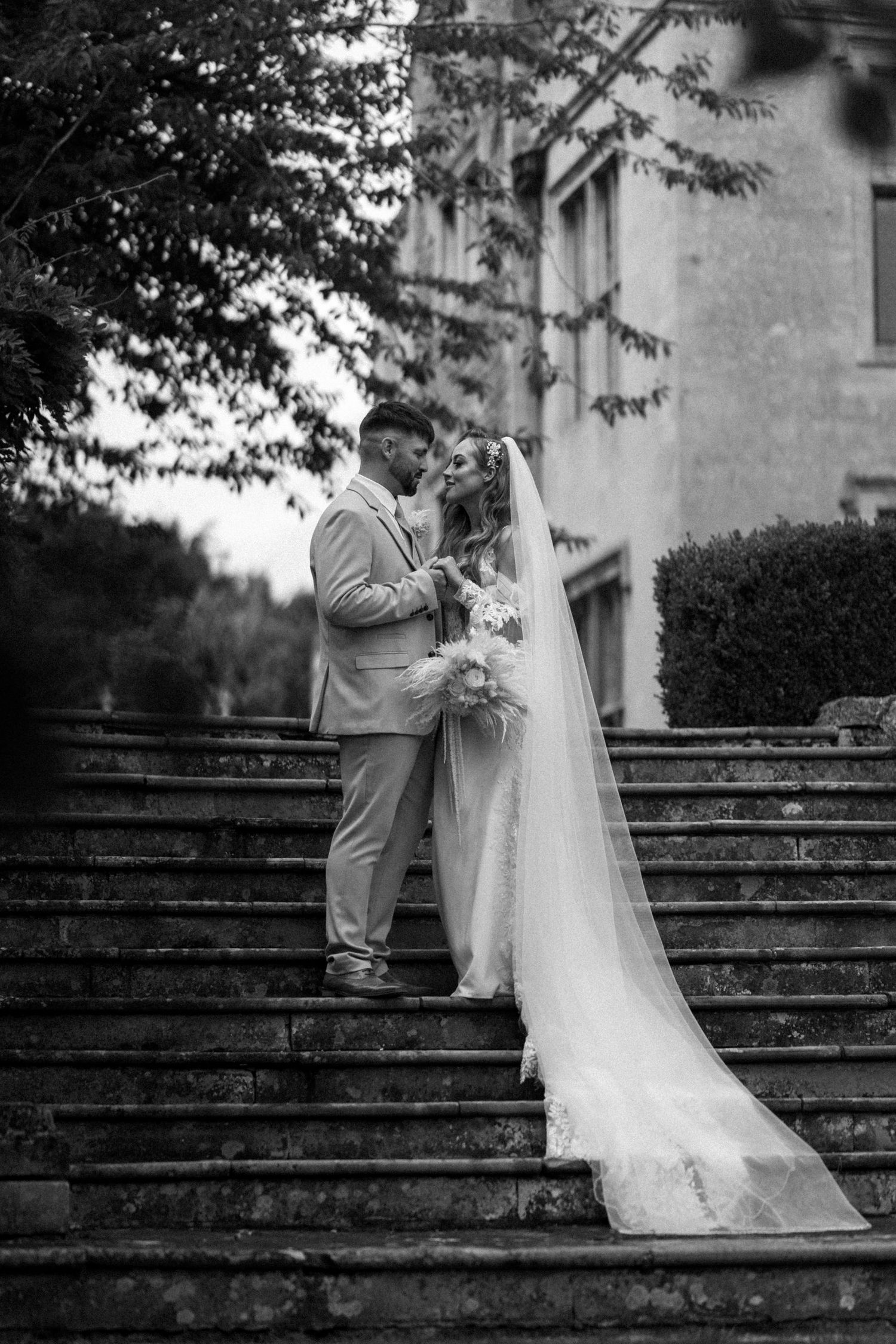 A romantic moment captured on grand stone steps outside a historic building.