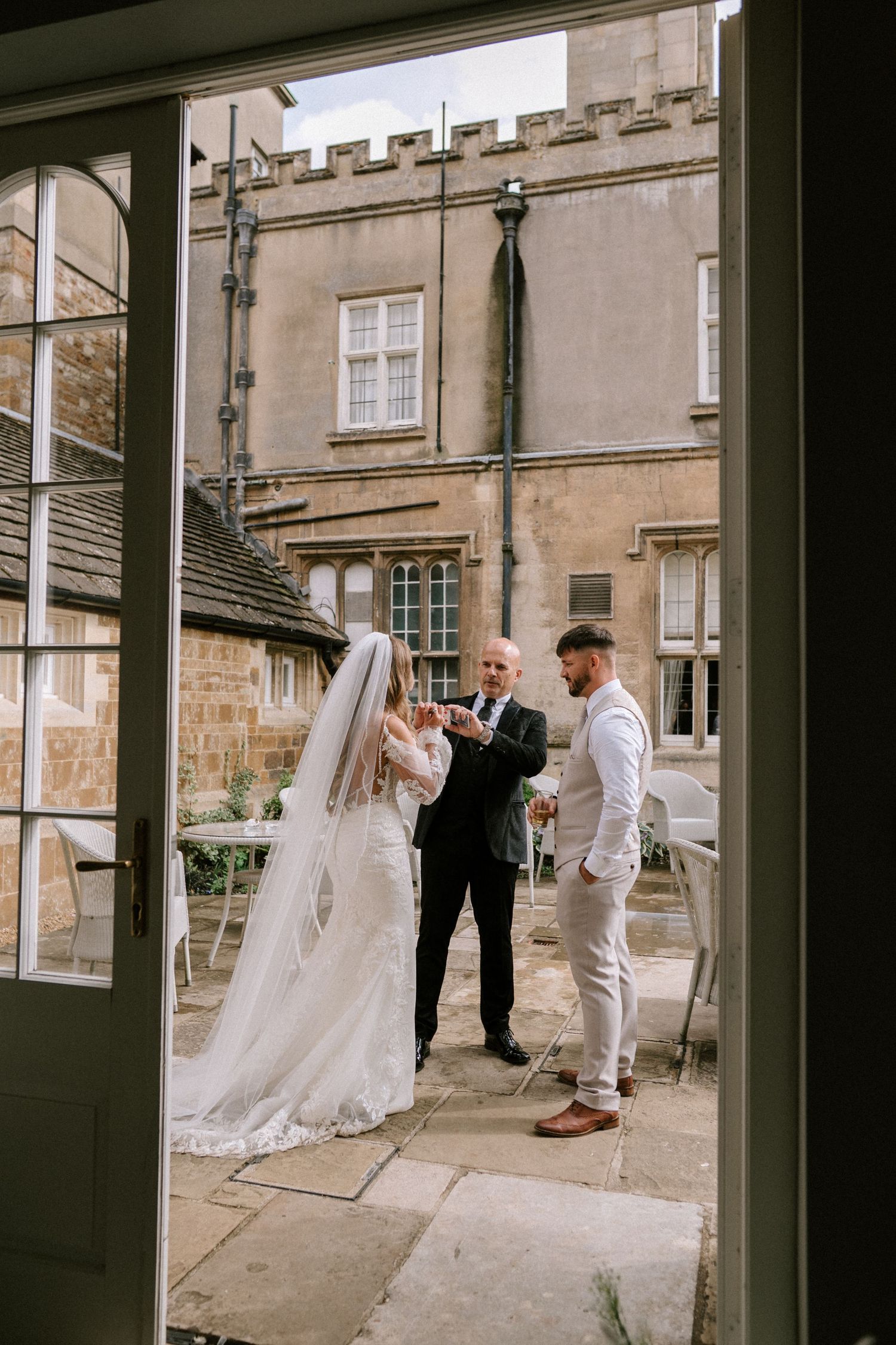 A wedding ceremony taking place on a balcony or terrace of a historic stone building.