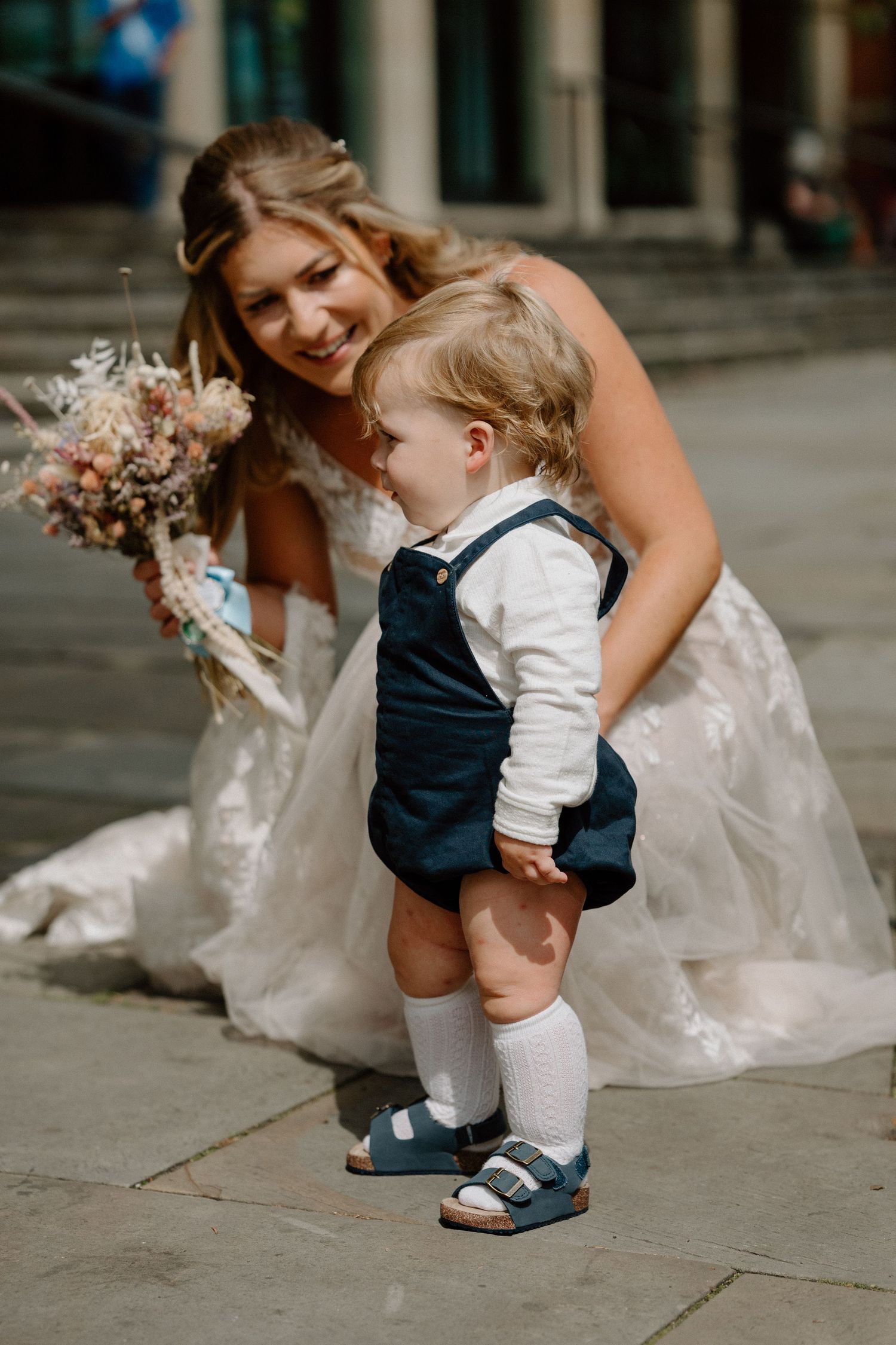 A sweet moment captured between a bride in white and a small child in formal attire in Northampton.