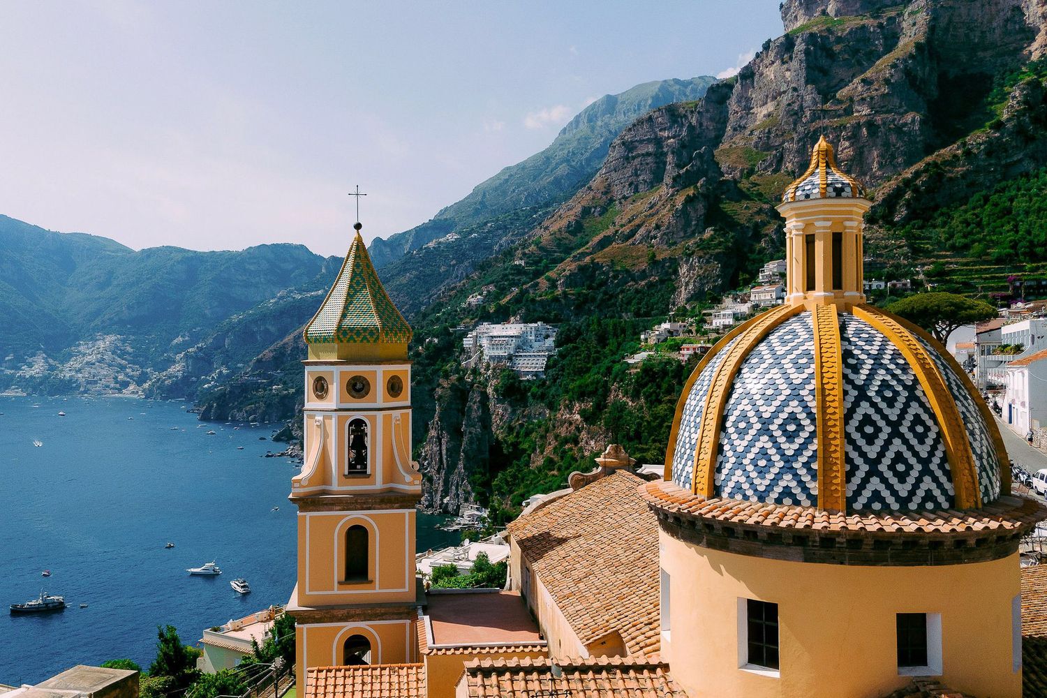 Scenic views of the Amalfi Coast in Italy showing colorful buildings, church towers, and dramatic coastal cliffs.