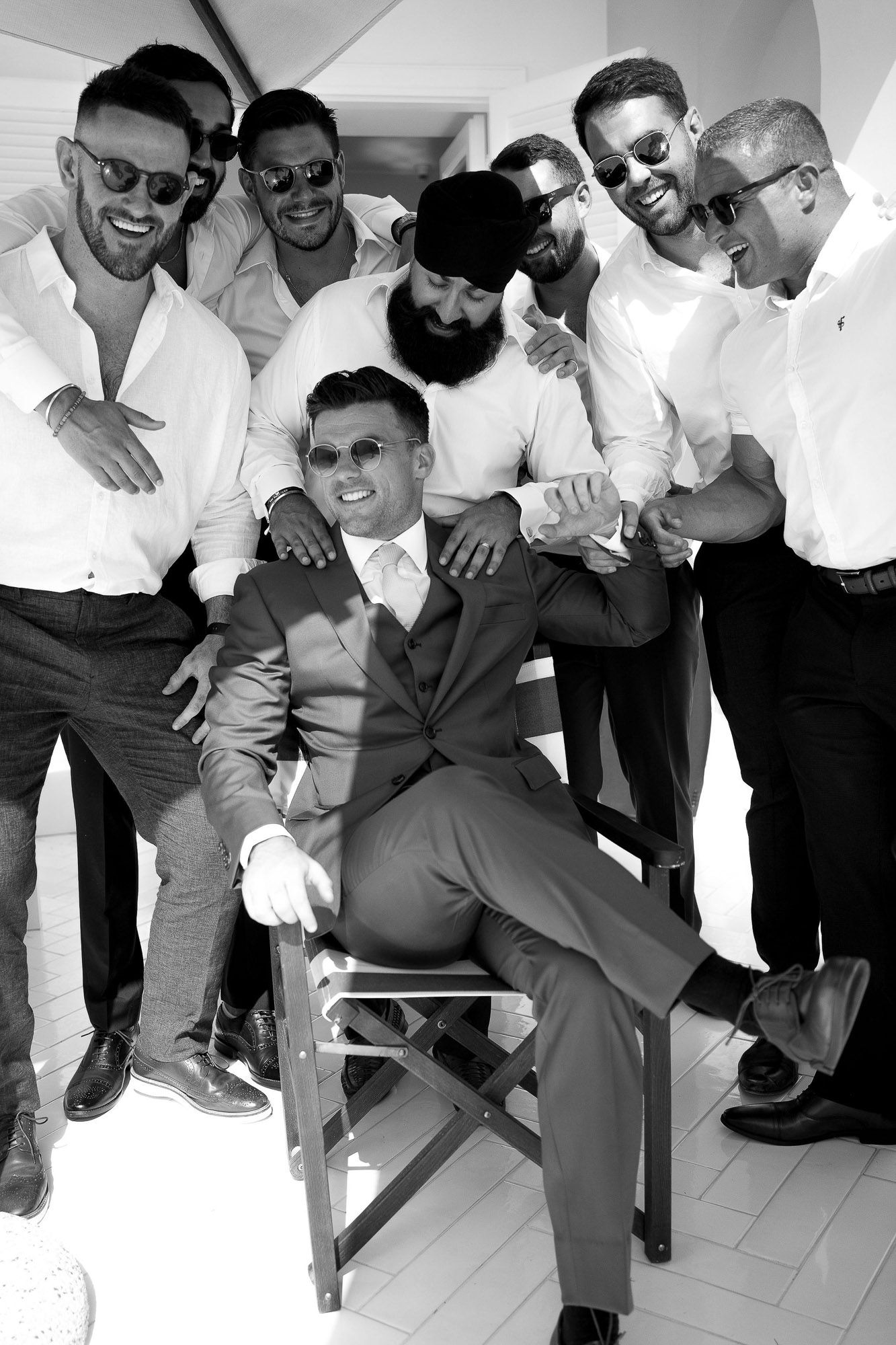 A black and white photo collage shows groomsmen in formal attire posing playfully for fun wedding photos.