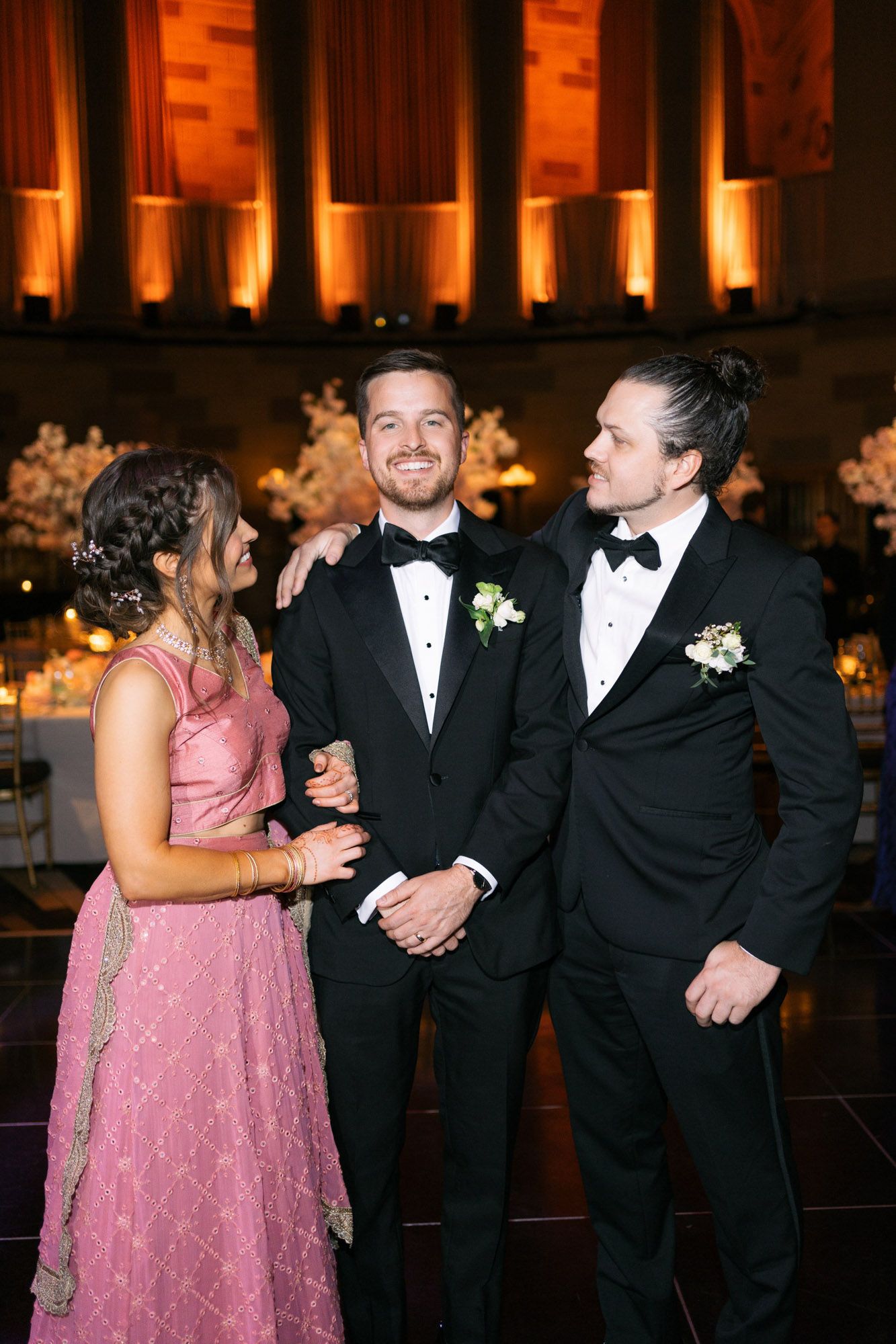 Wedding party in black tuxedos and pink dresses dancing and celebrating during the reception.