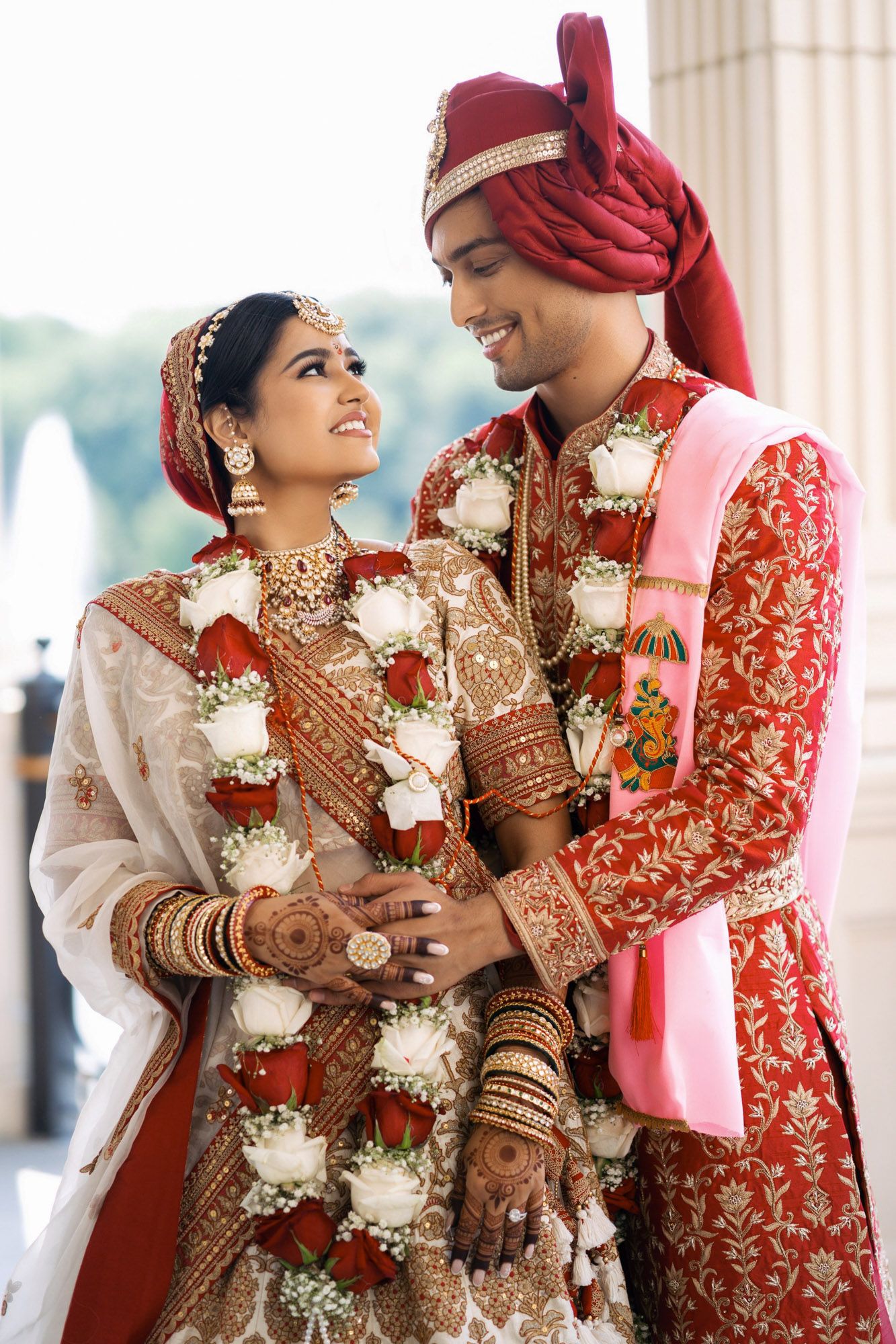 A couple in traditional Indian wedding attire shares romantic moments in a series of candid photographs.
