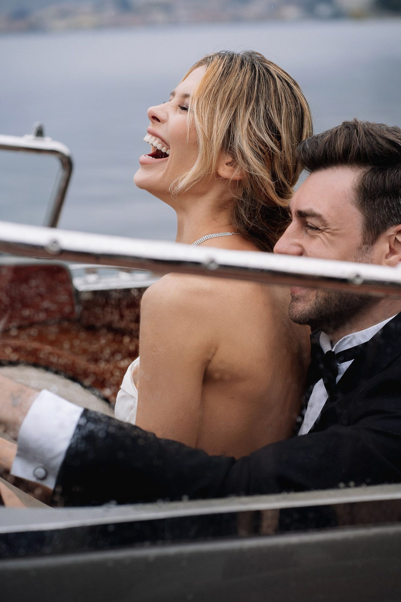 A romantic couple shares intimate moments while lounging together in a boat on the water.