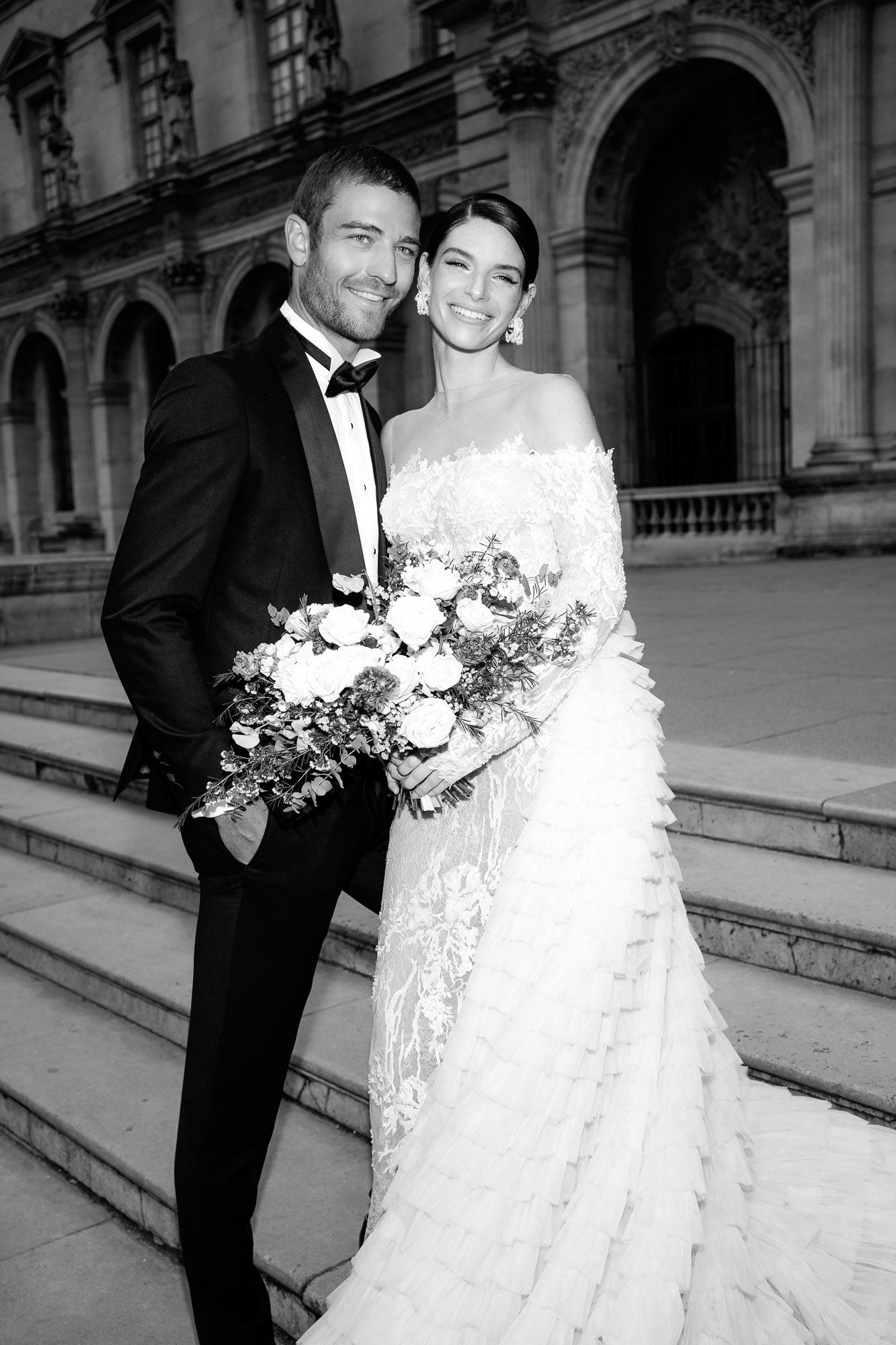 A black and white wedding photograph series showing a couple in formal attire posing on elegant stone steps.