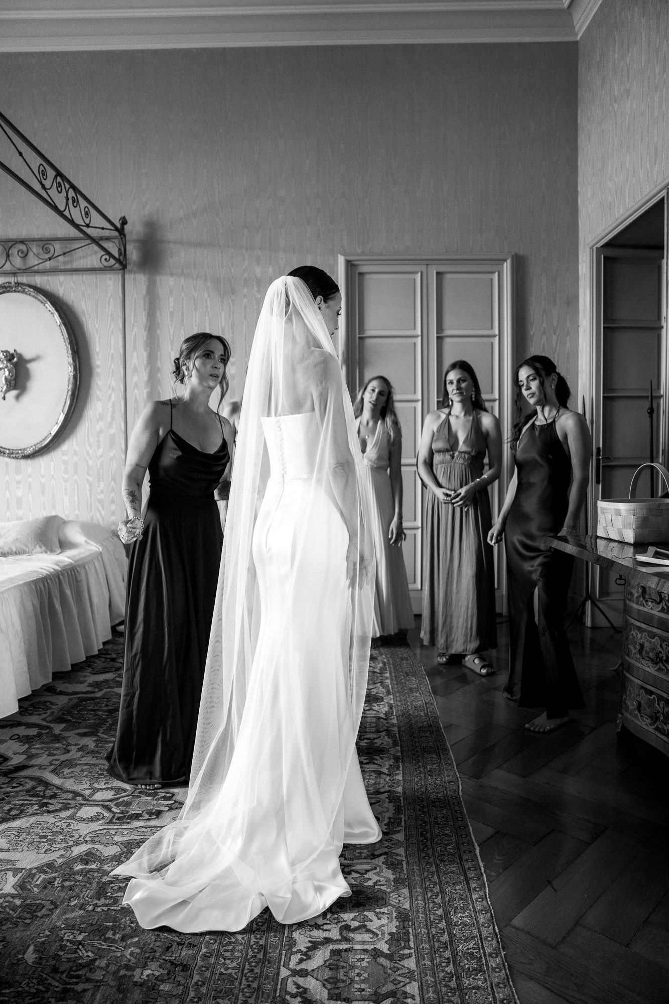 A series of black and white photographs showing wedding preparations in an elegant room with hardwood floors.