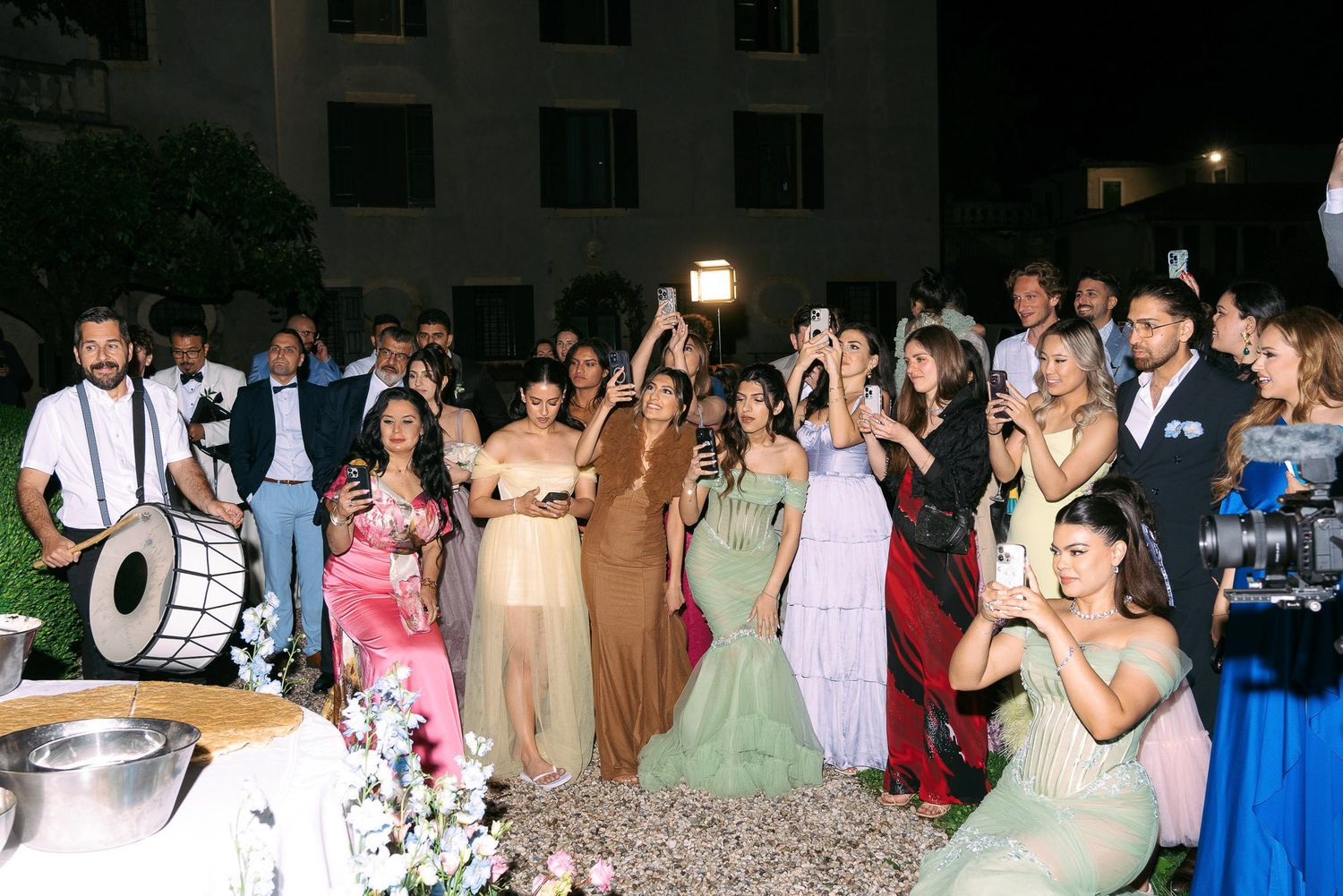 Wedding guests dancing and celebrating together on a dance floor at an evening reception.