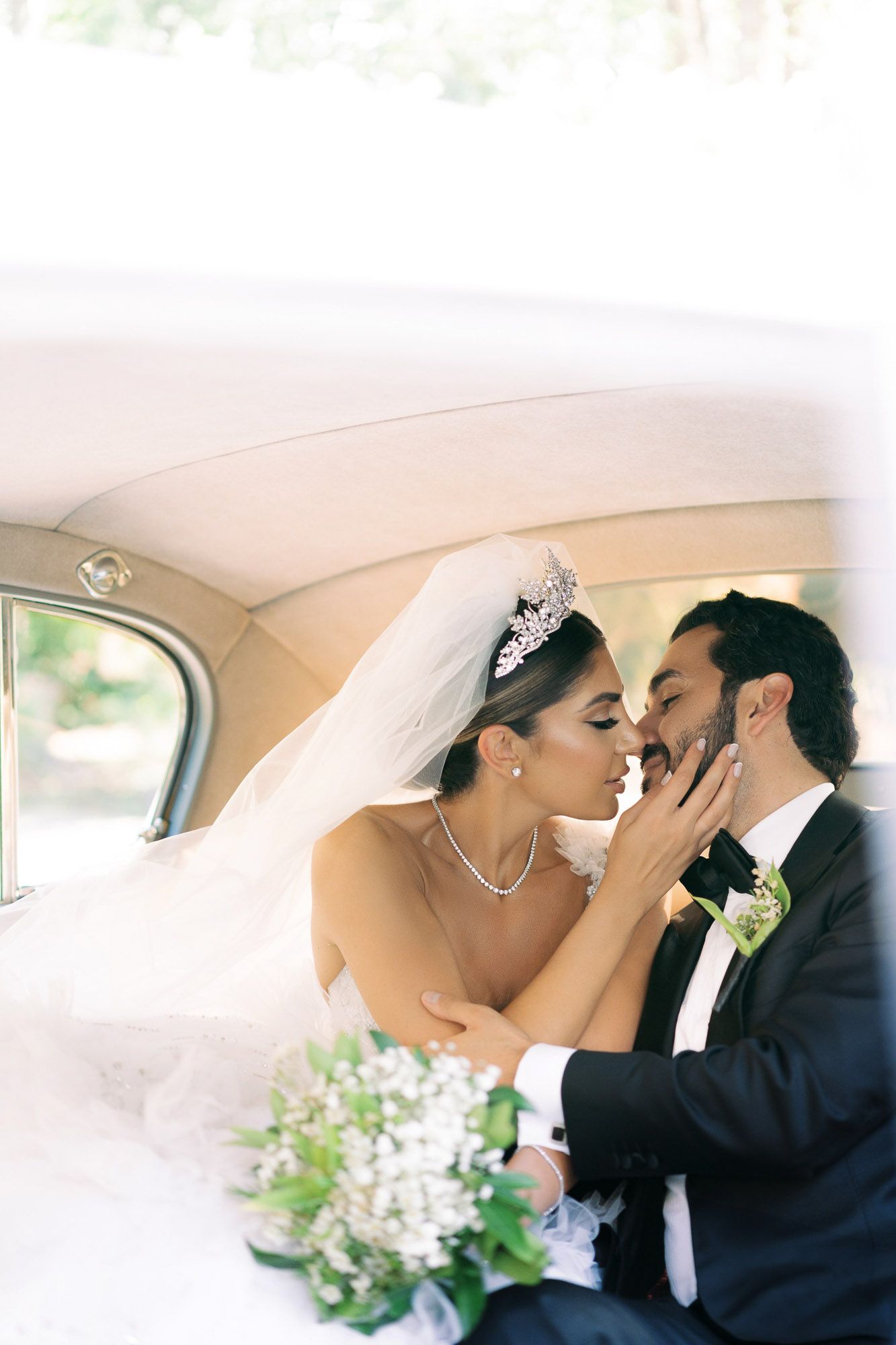 Romantic black and white wedding photo series showing tender moments between newlyweds inside a car.