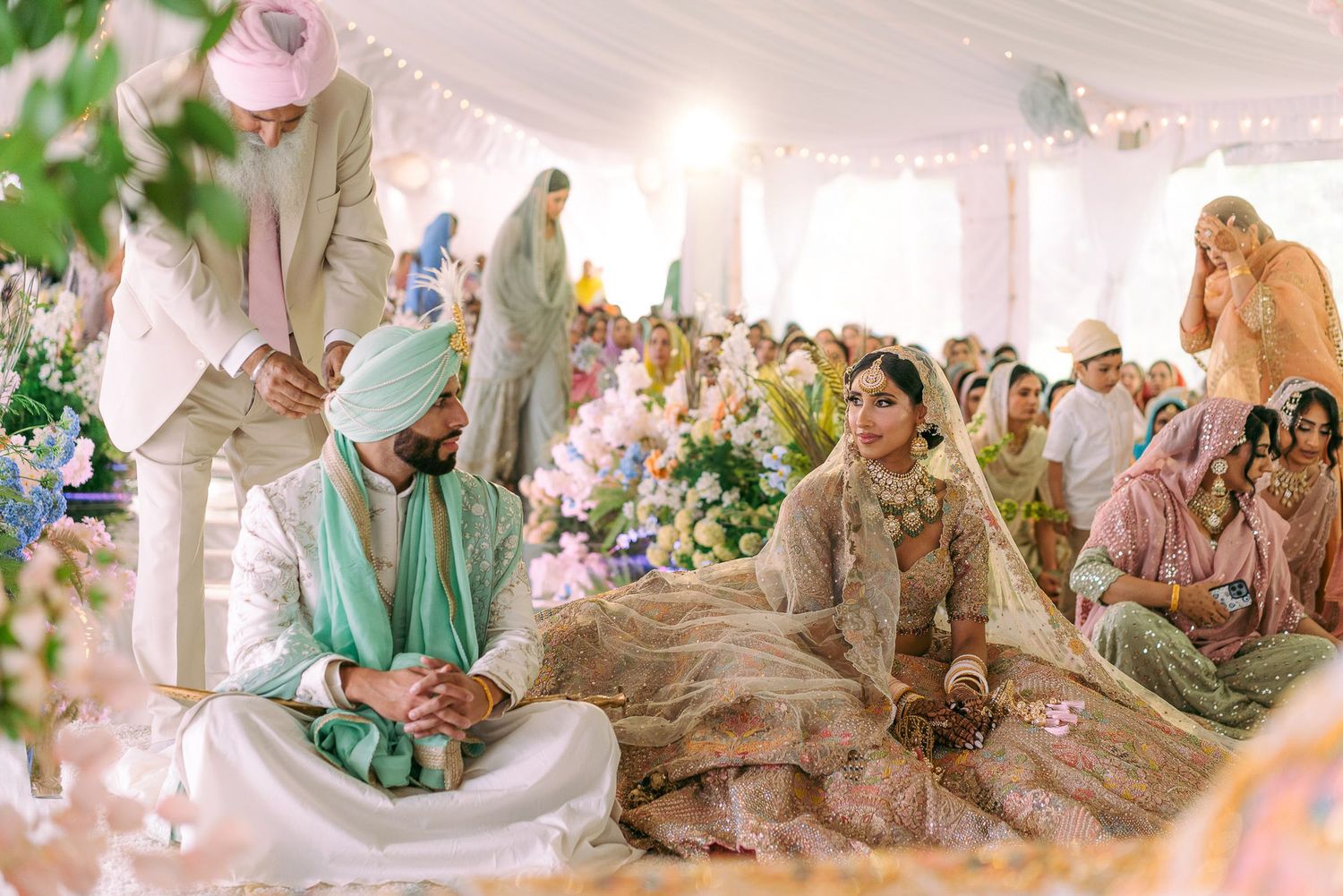 A dreamy wedding Indian ceremony setup with soft pink and white decor, floral arrangements, and elegant seating arrangements.