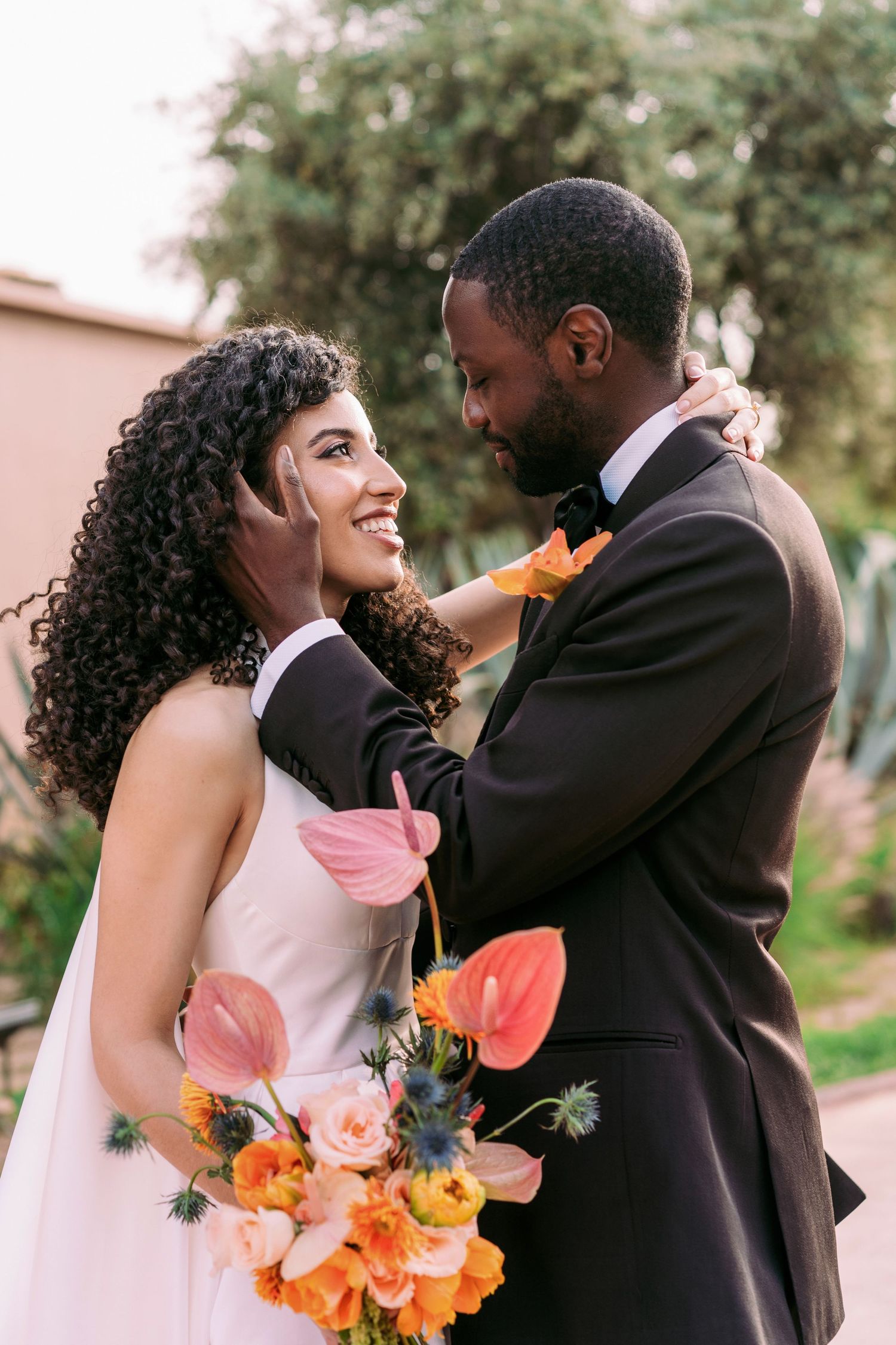 Wedding couple sharing intimate moments with colorful floral bouquet.