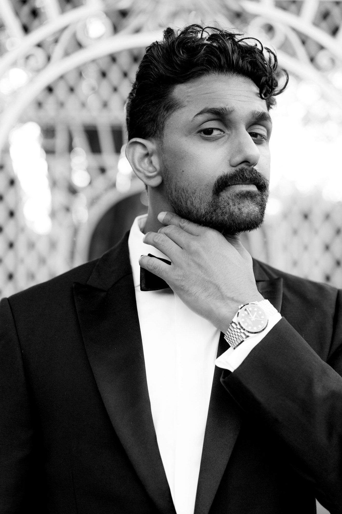 Black and white photo series showing a person in a formal suit and white shirt posing in different angles.