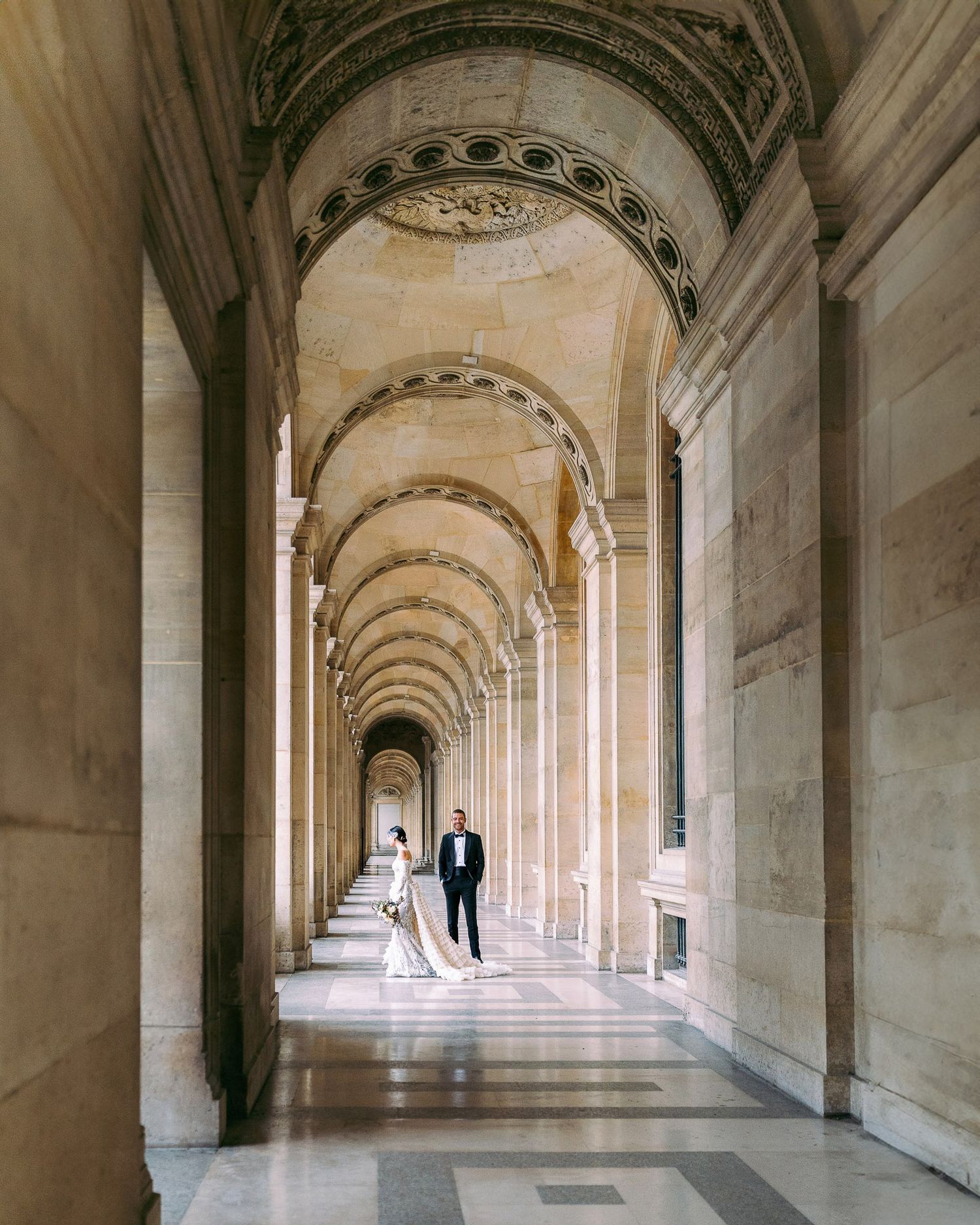 Architectural detail of a long arched colonnade hallway with repeating columns and vaulted ceiling in classical style.