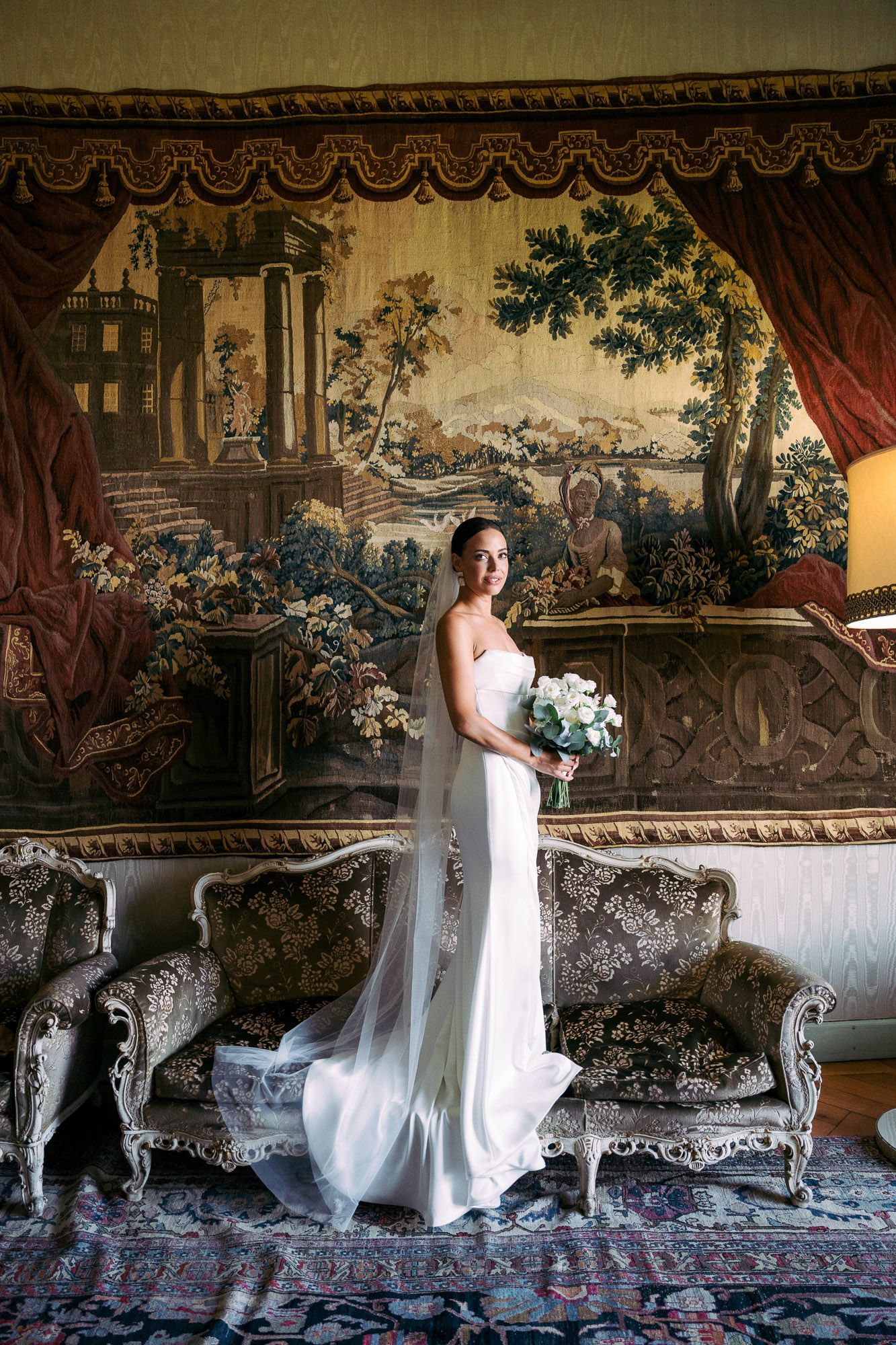 A sequence of elegant bridal portraits against ornate tapestries and antique furniture in a luxurious historic room.