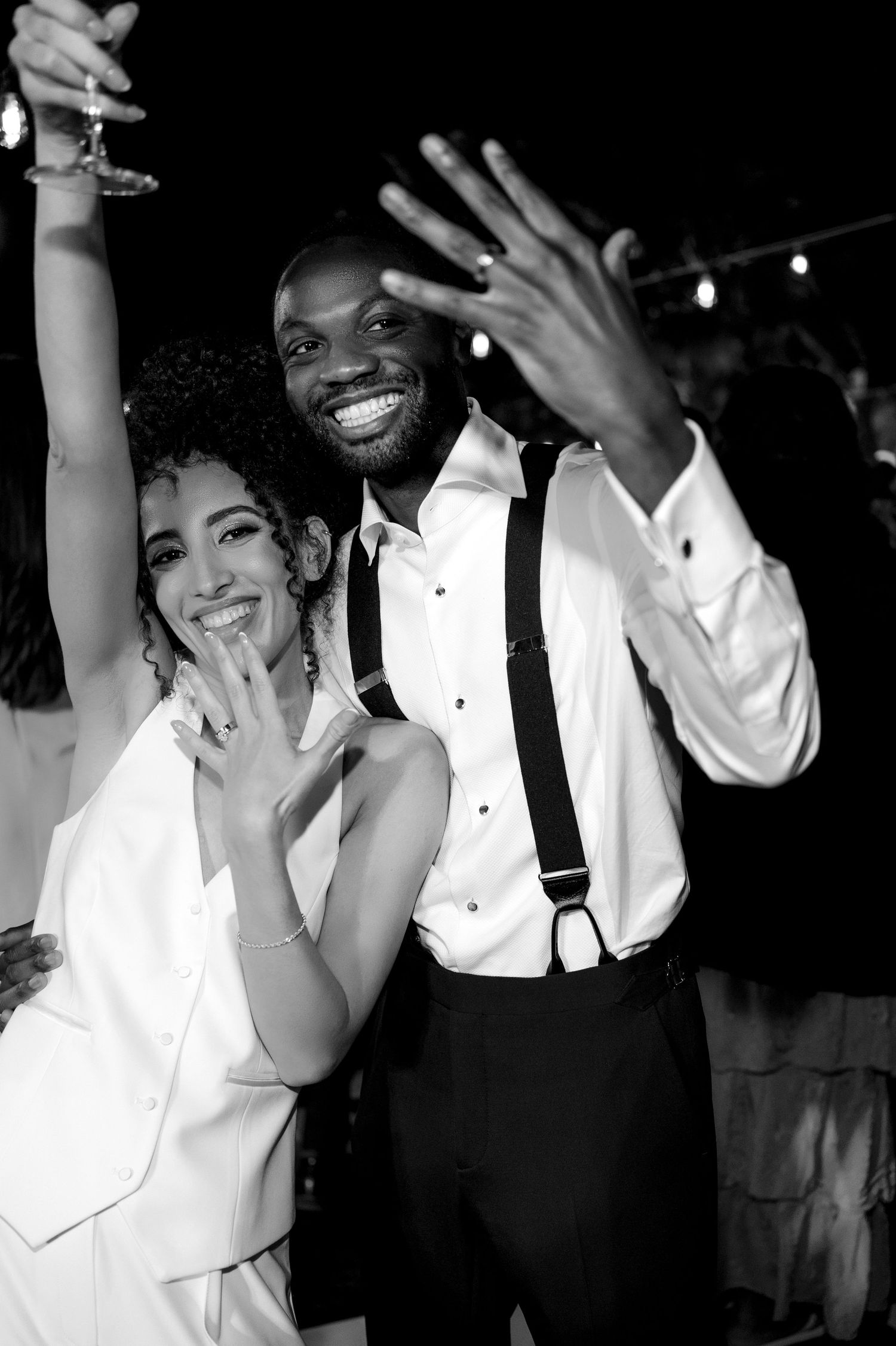 Joyful newlyweds showing off their rings at their wedding reception.