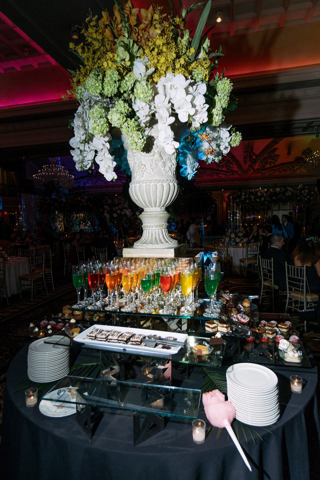 Elegant banquet tables with dark blue linens and white floral centerpieces set up for an upscale event reception.