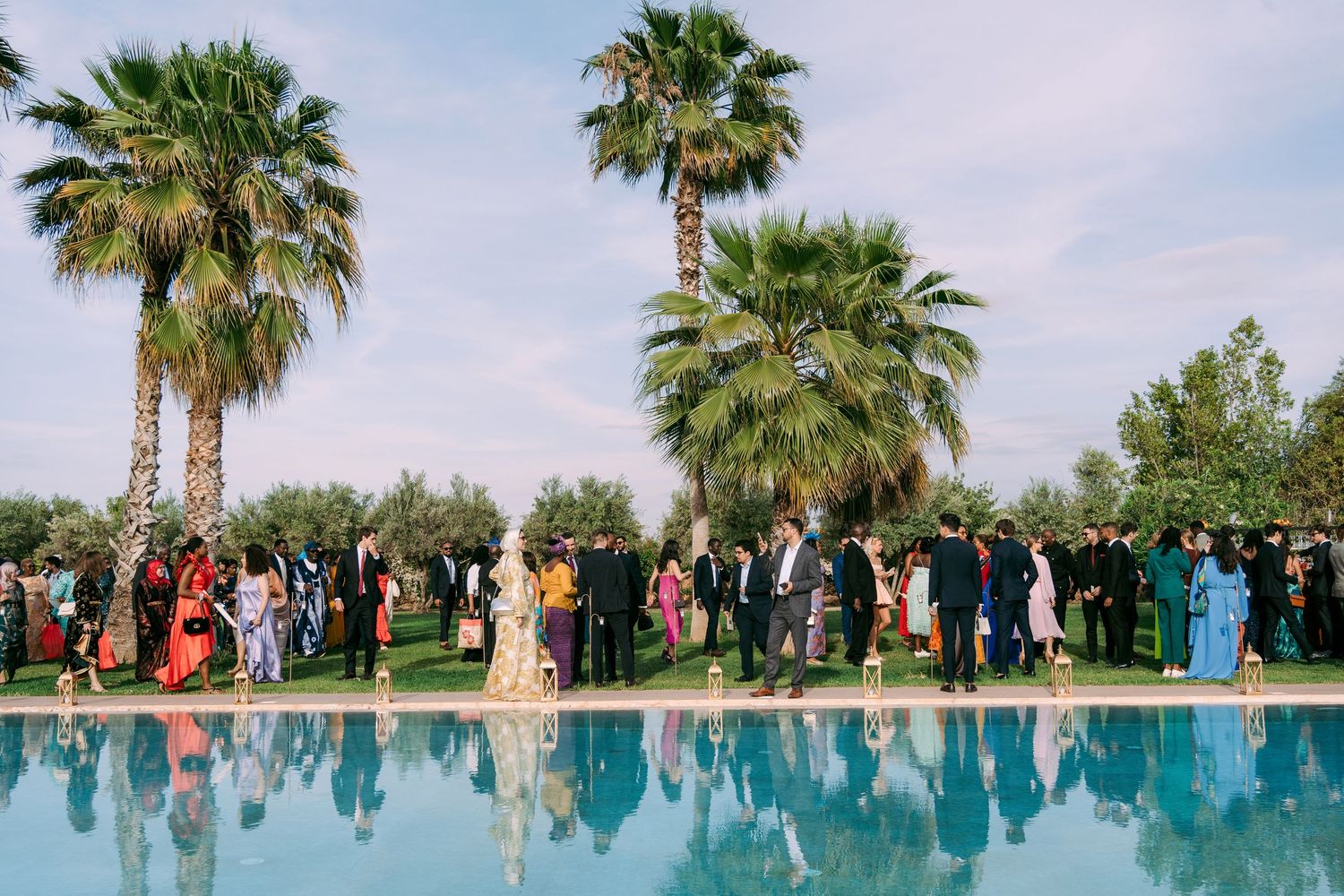 Scenic outdoor wedding venue with palm trees and turquoise pool reflections.
