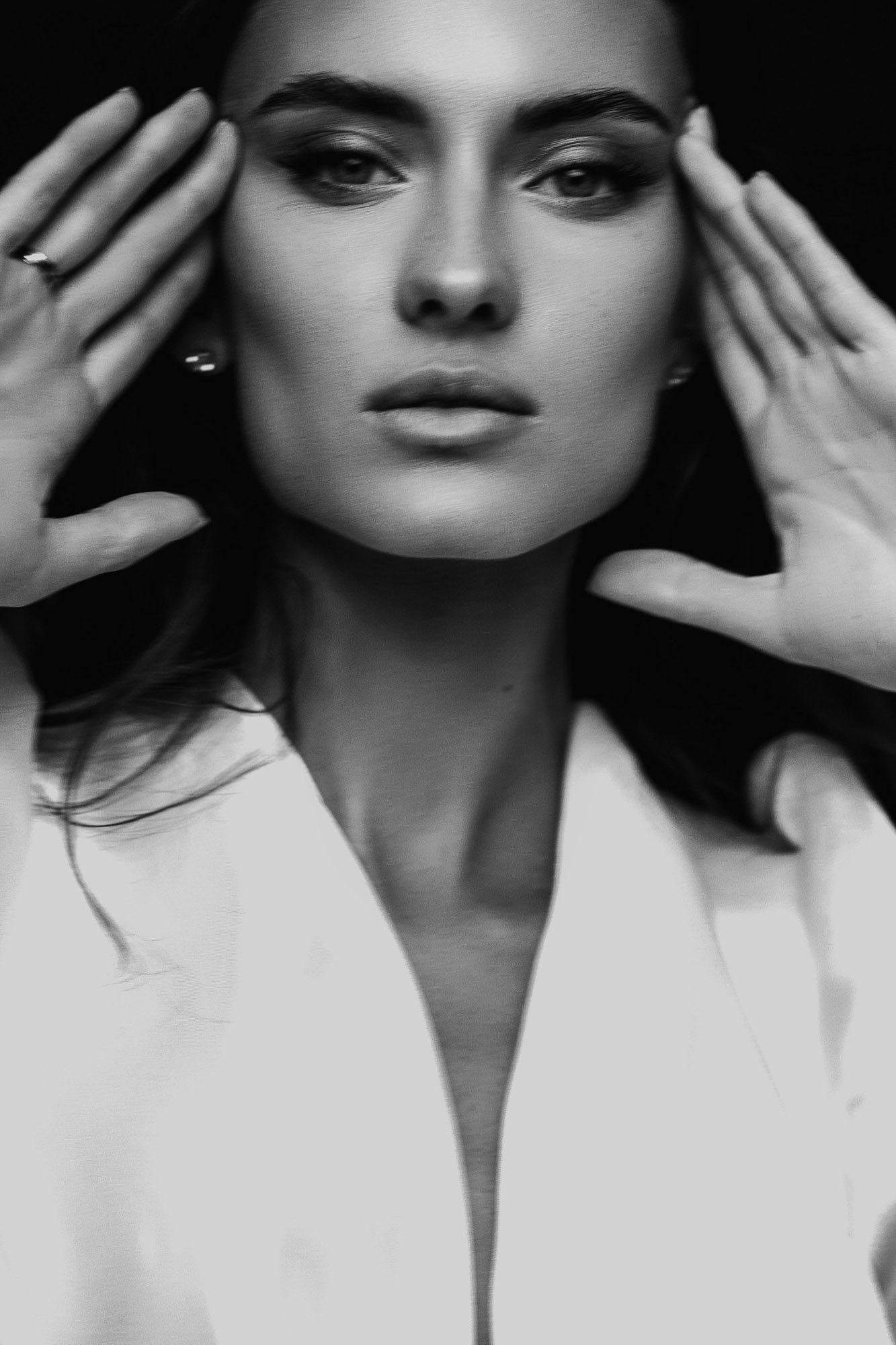 A dramatic black and white fashion portrait series showing close-up expressions with hands framing the face.