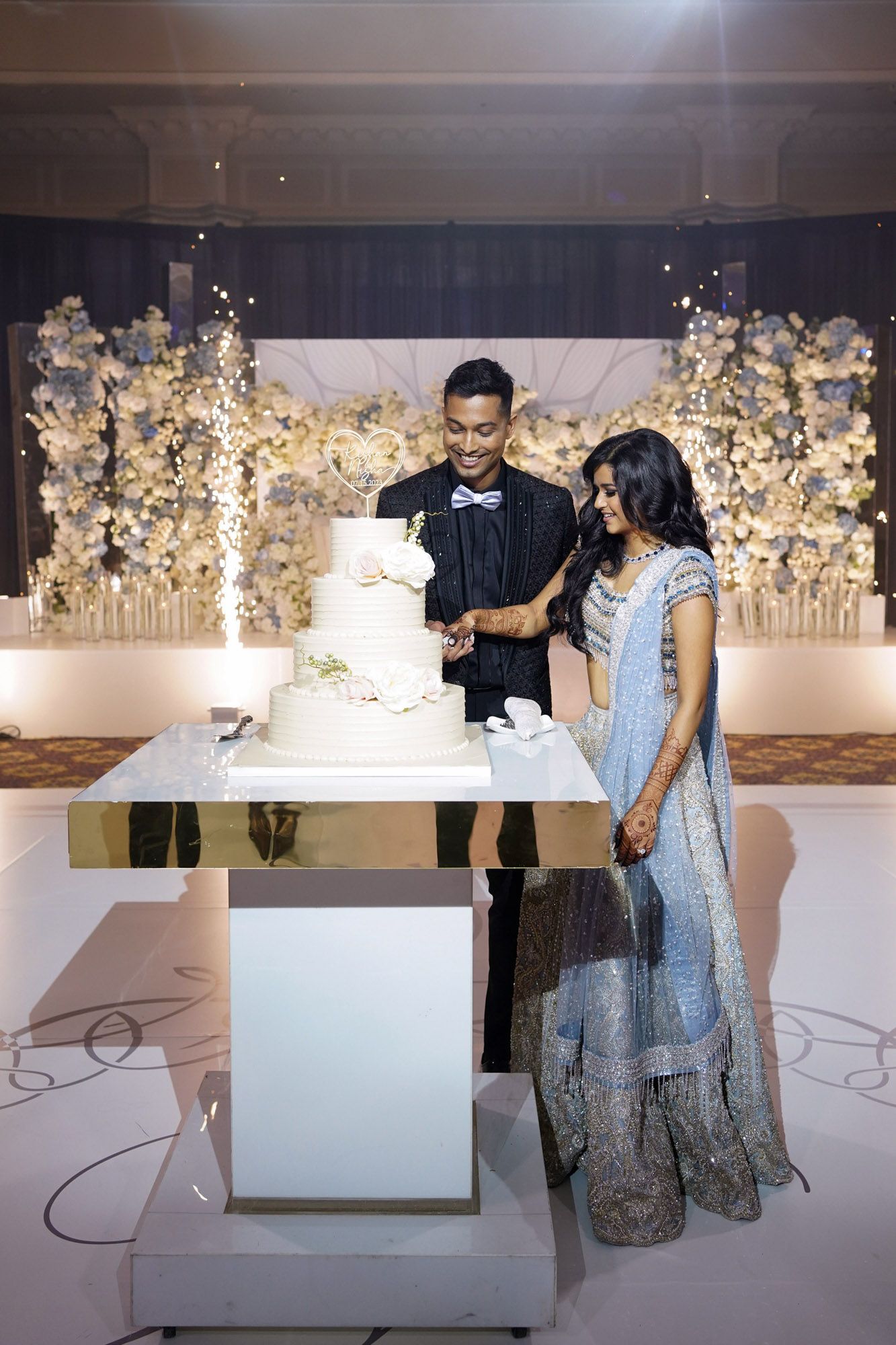 Wedding reception venue decorated with elegant white floral arrangements and modern display panels.