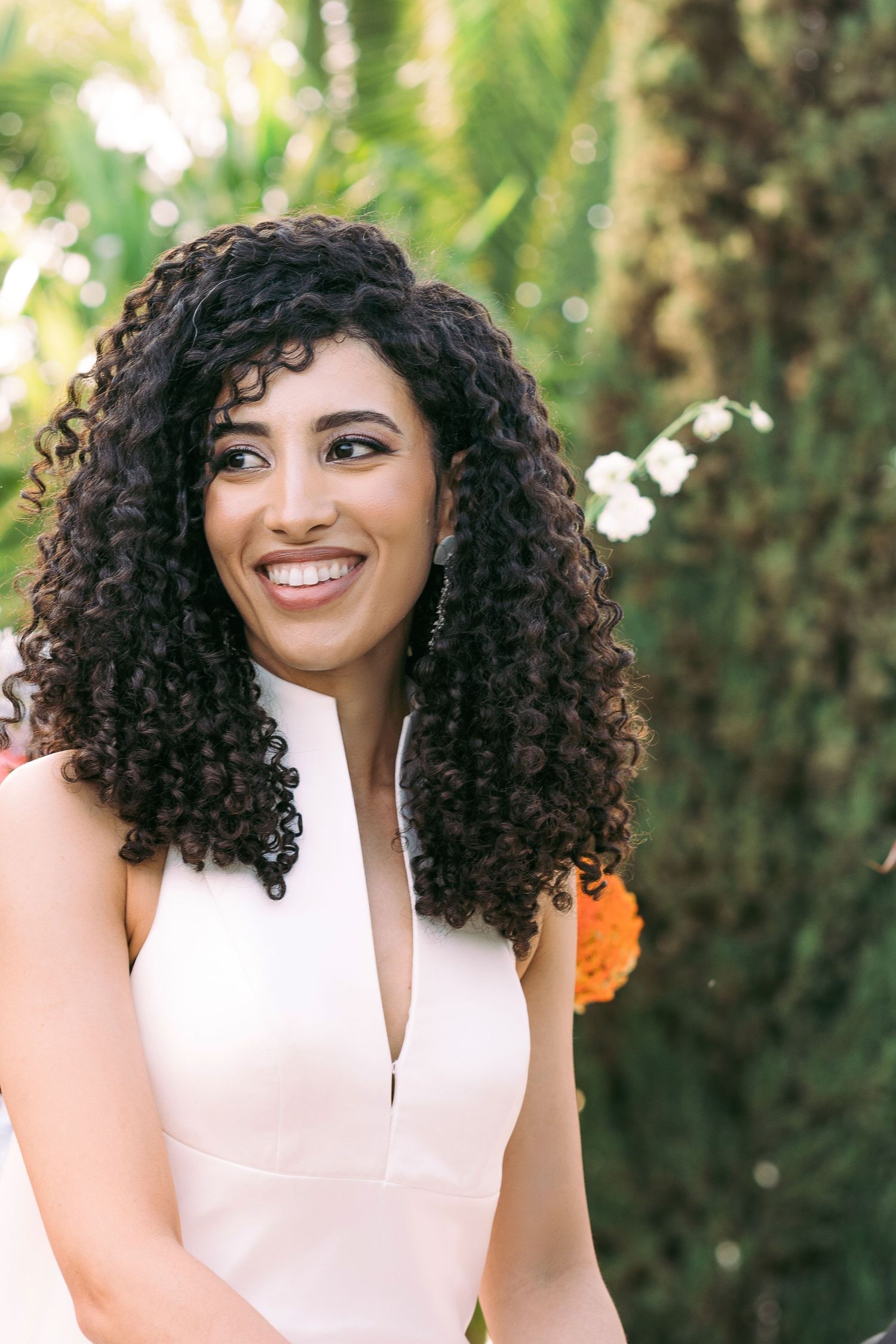 Elegant bridal portrait showcasing a white v-neck dress in a natural outdoor setting.